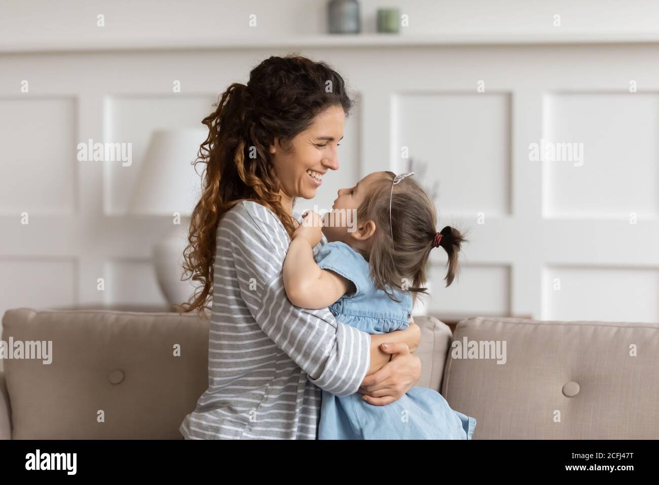 Liebkosung Mutter kuschelt kleine Tochter zum Ausdruck bringen Liebe und schätzen Stockfoto