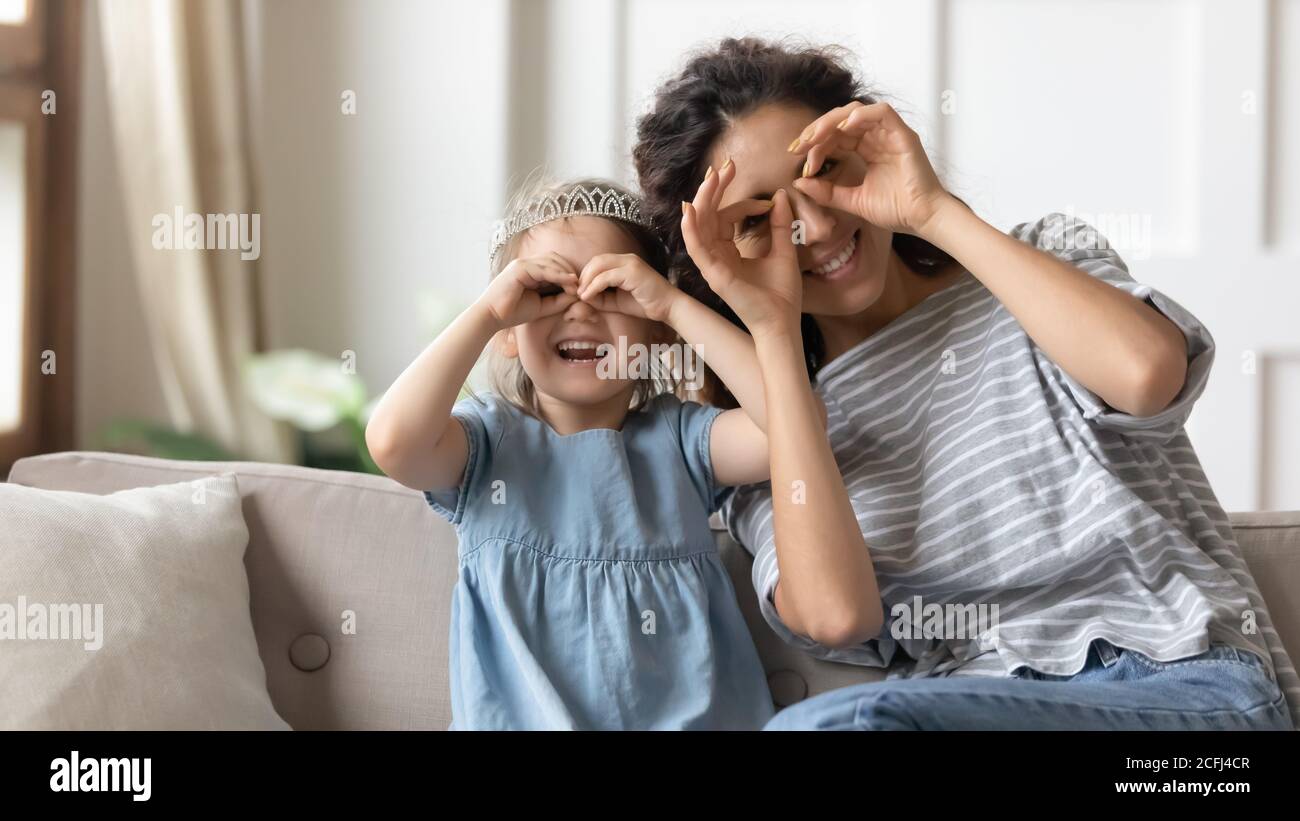 Mutter und Tochter mit Spaß machen mit Fingern Augenform Stockfoto