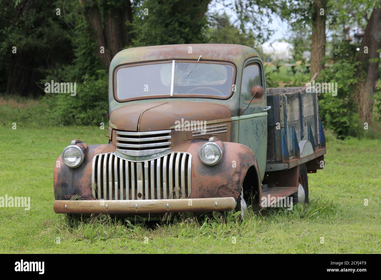 Old Chevy Truck mit Gras, Bäumen, draußen im Land erschossen Nahaufnahme. Stockfoto
