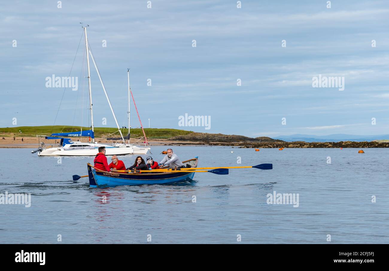 North Berwick, East Lothian, Schottland, Großbritannien, 6. September 2020. Erste Reihe nach der Sperre: Mitglieder des NB Coastal Ruderclubs sind heute Morgen zum ersten Mal seit der Sperre im März von West Bay aus aufbrechen. Covid-sichere Maßnahmen sind vorhanden, einschließlich Ruderer, die Gesichtsmasken tragen. Die Crew ruht aus West Bay Stockfoto