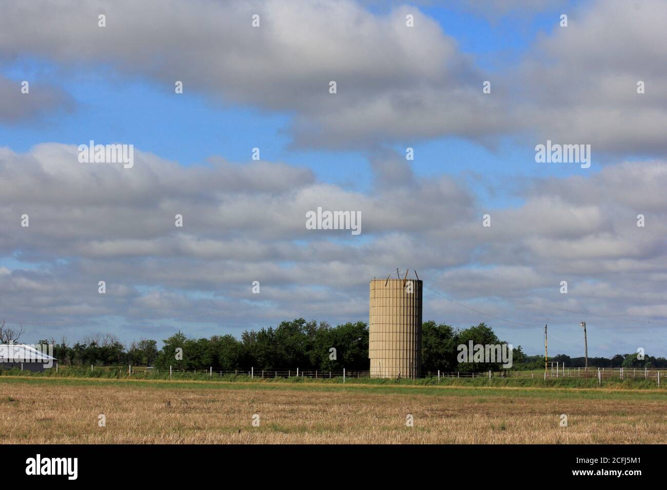 Kansas Farmsilo mit blauem Himmel und weißen Wolken auf dem Land. Stockfoto