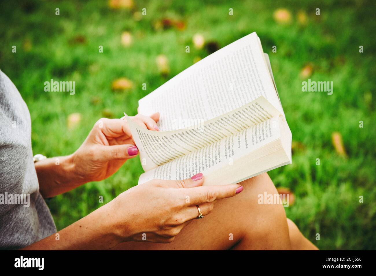 Frauenhände halten ein Buch, blättern, Nahaufnahme Stockfoto