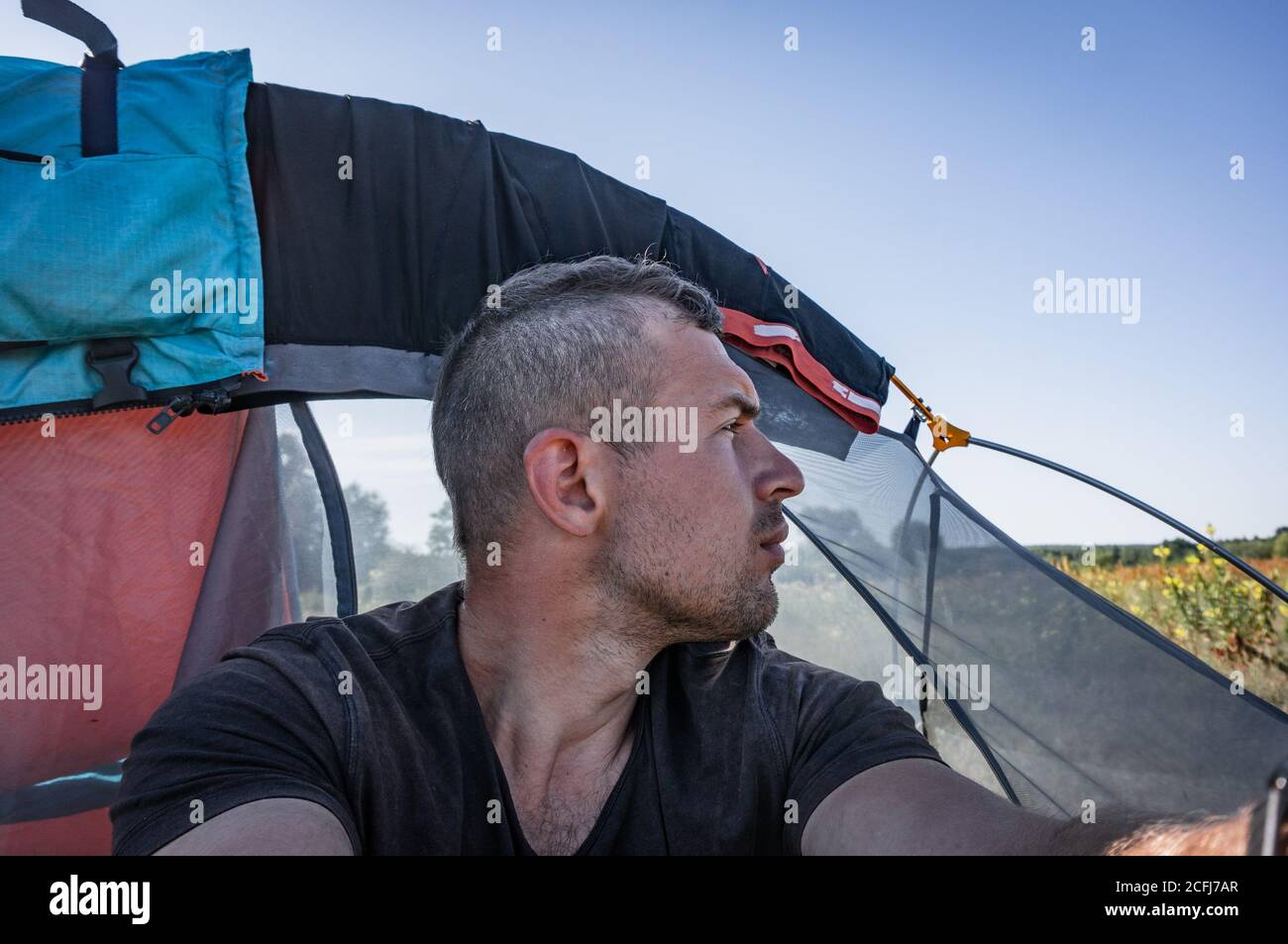 Selfie eines Punkers auf dem Hintergrund eines Zeltes, Alltag auf einer Wanderung, Stockfoto