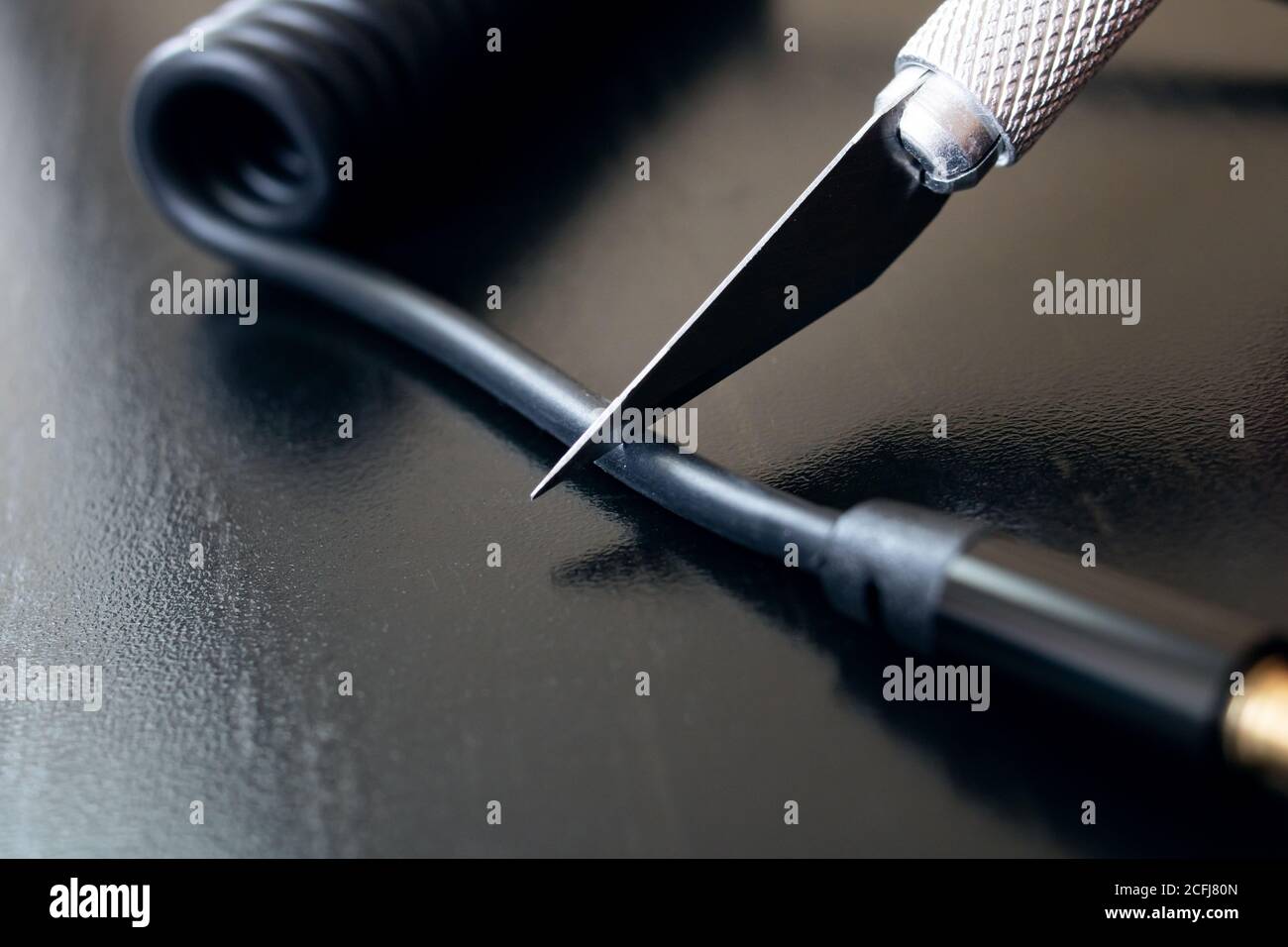 Schneiden Sie dicken Draht mit einem technischen Skalpell Stockfoto