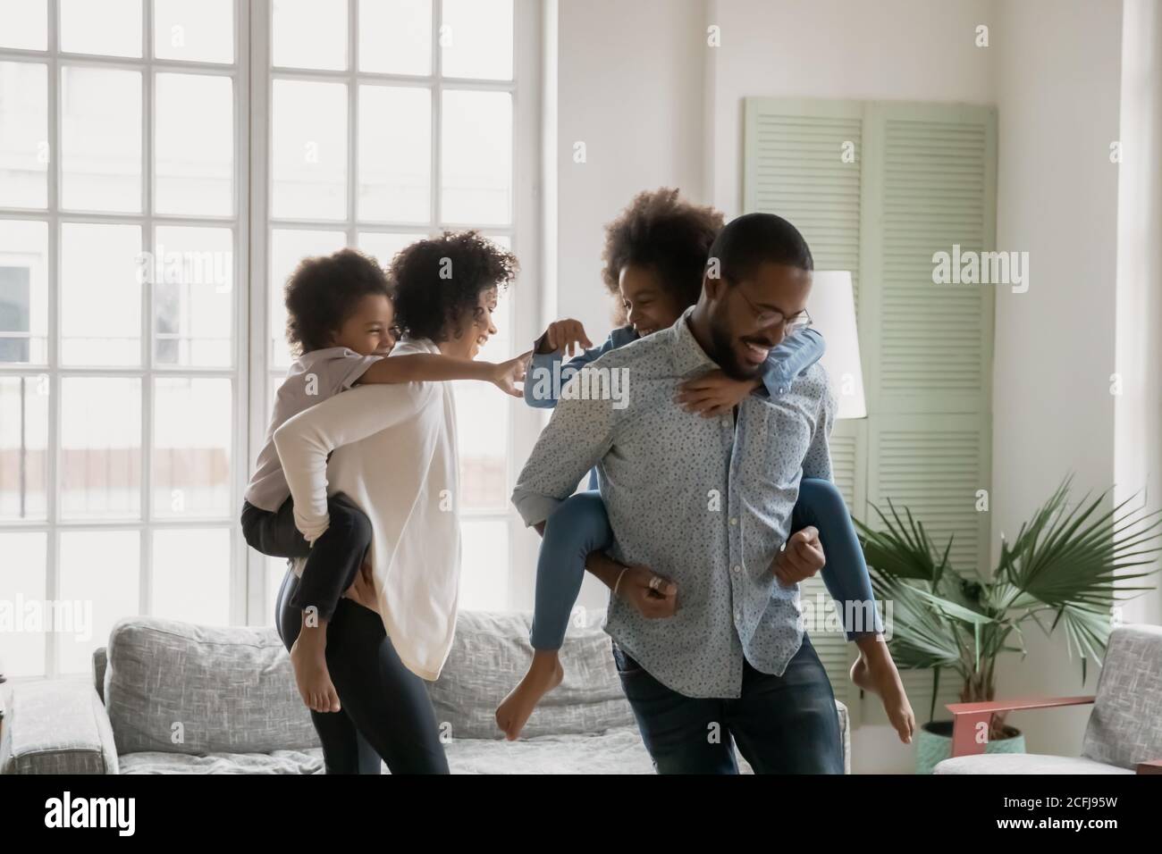 Glückliche afroamerikanische Familie spielen aufholen zu Hause. Stockfoto