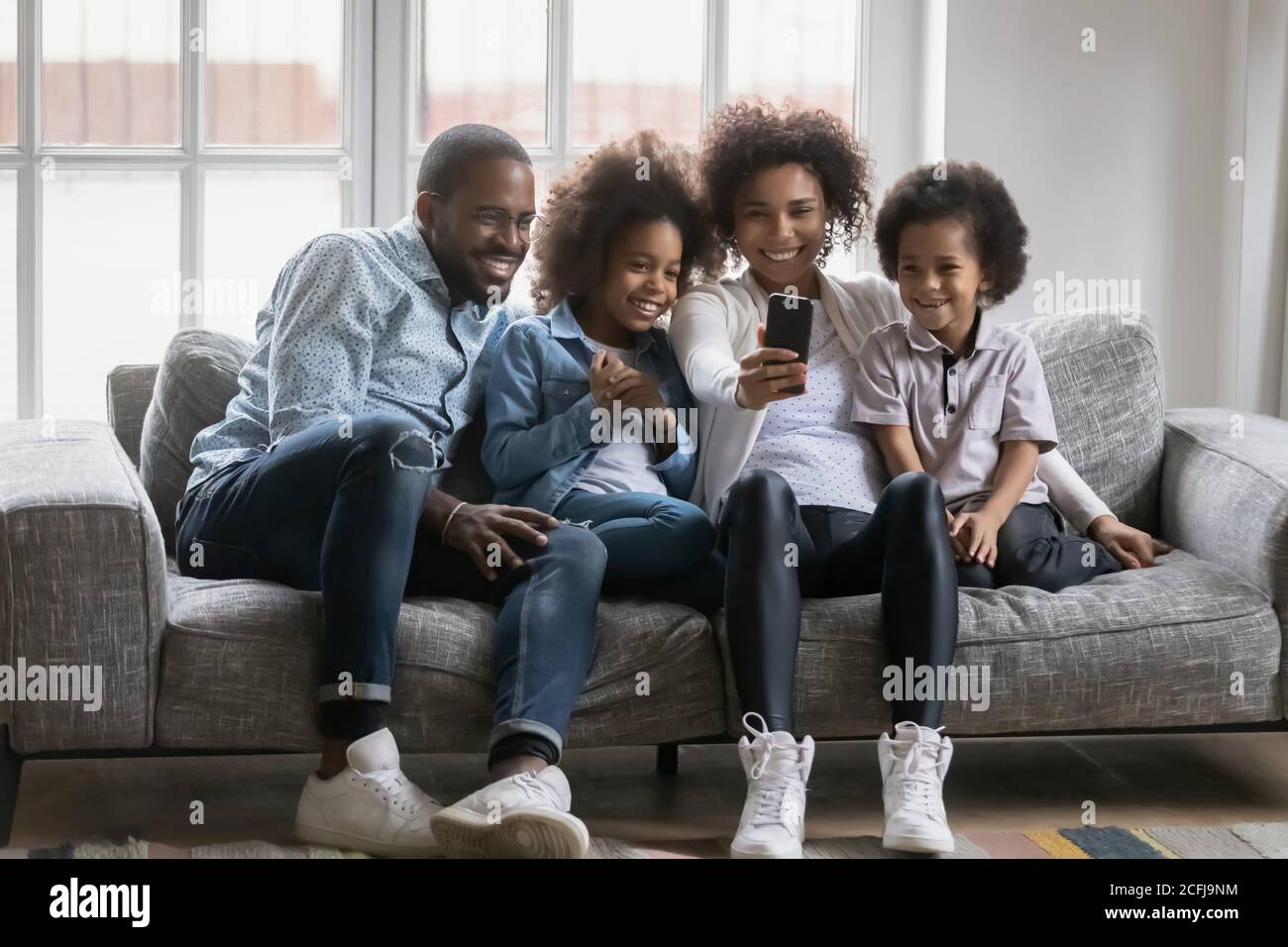 Glückliche afroamerikanische Familie posiert für Selfie Foto auf Handy. Stockfoto