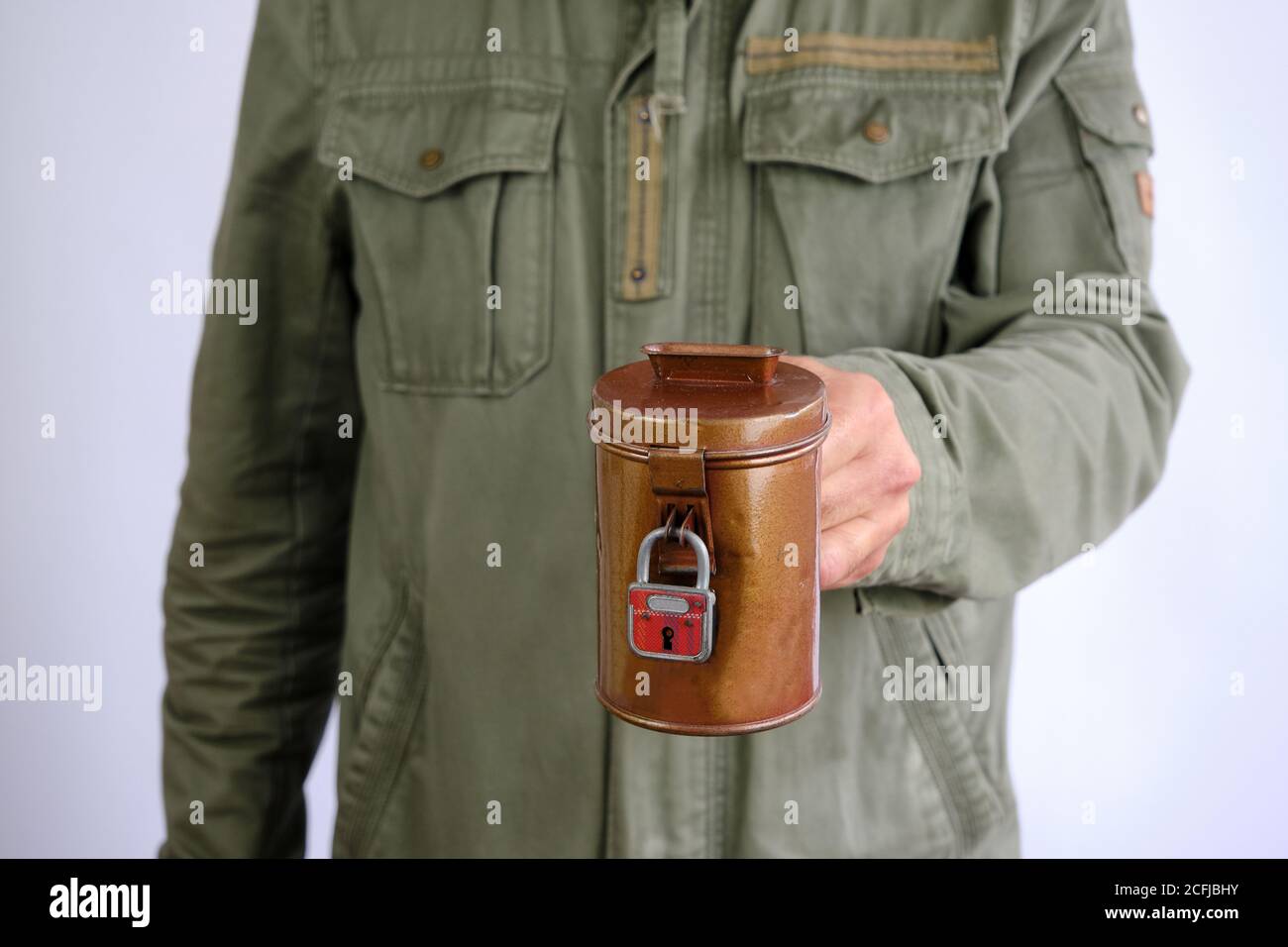Man holdiong eine Vintage Geld Sammelbox mit Vorhängeschloss, spendensose. Sammeln Sie Geld für einen guten Zweck. Isoliert auf weißem Hintergrund Stockfoto