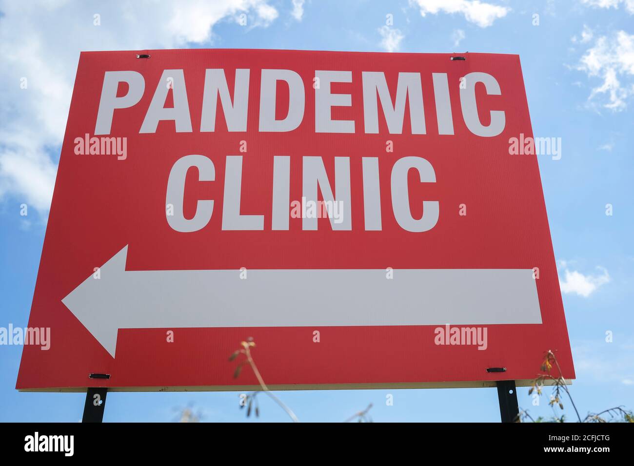 Low-Angle-Ansicht eines Pandemic Clinic Zeichen gegen bewölkt Himmel Stockfoto