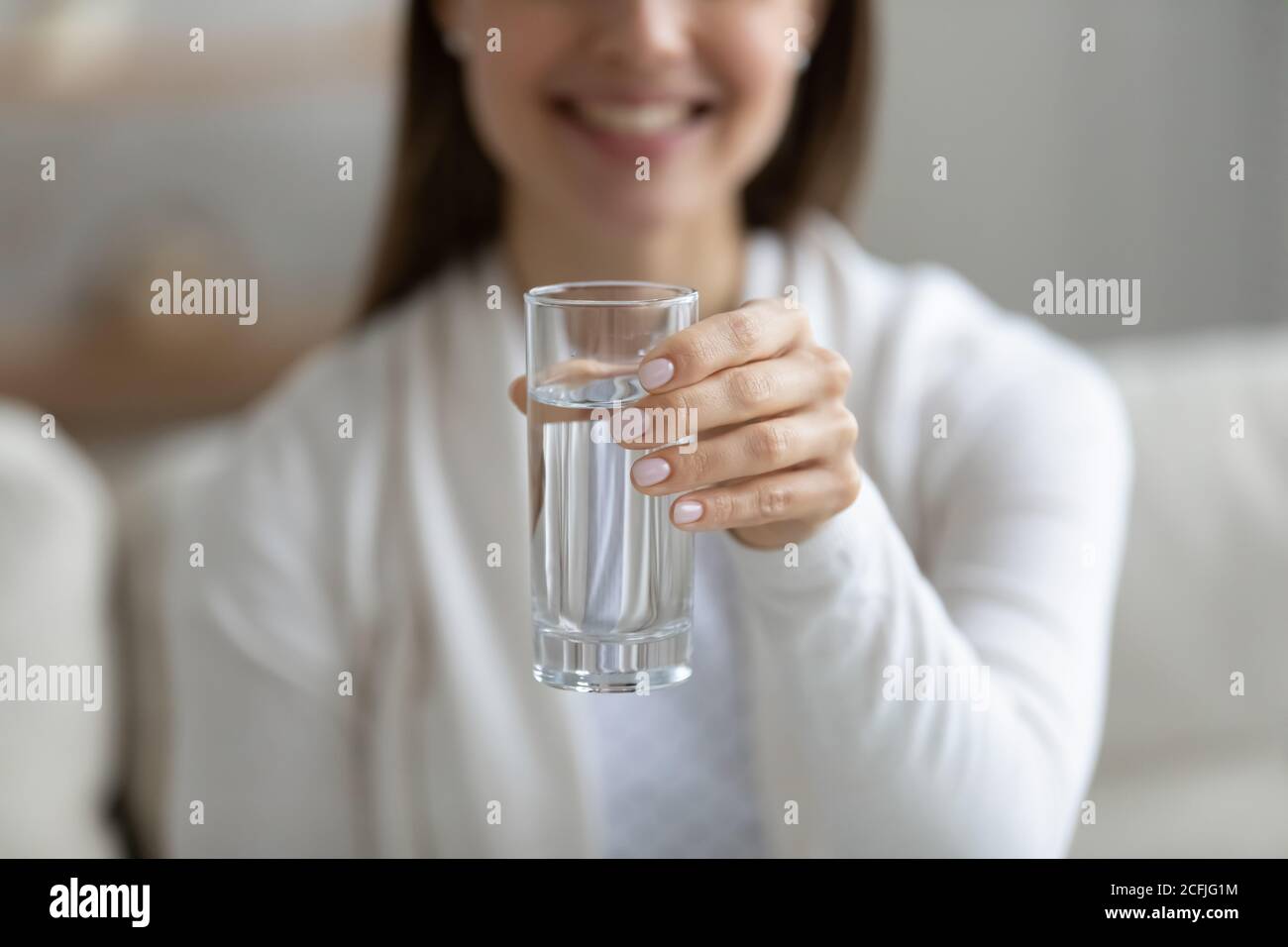 Close up Lächeln gesunde junge Mädchen hält Glas reines Aqua. Stockfoto
