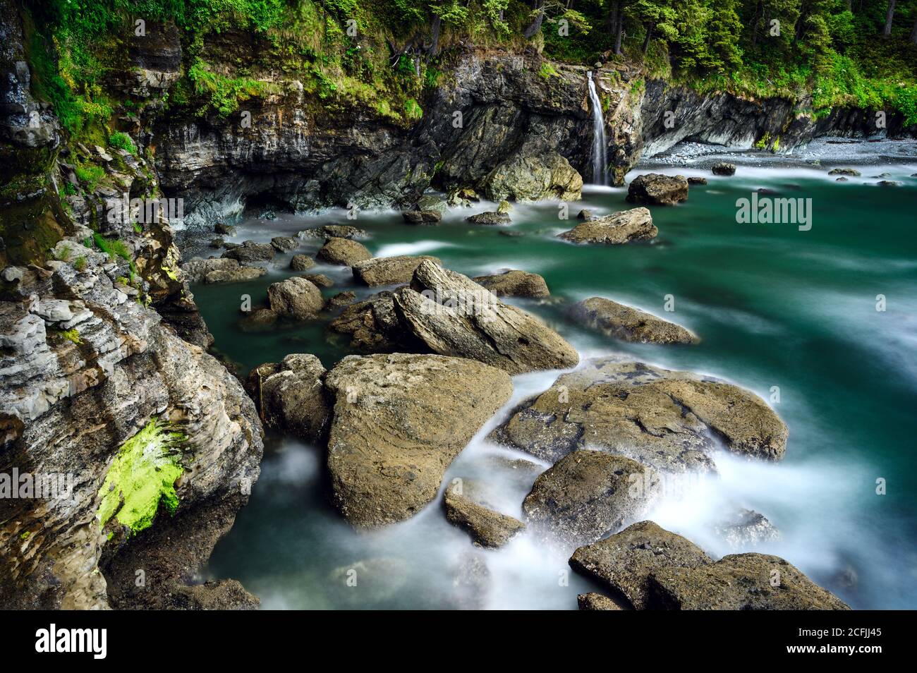 Bach mit langer Exposition umgeben von Felsen und Grün in Juan de Fuca Marine Trail, Kanada Stockfoto