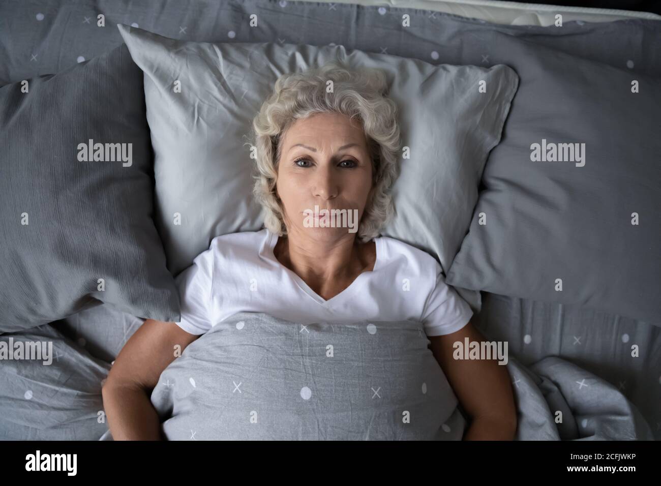 Draufsicht schlaflose reife Frau im Bett liegend, Schlaflosigkeit Konzept Stockfoto