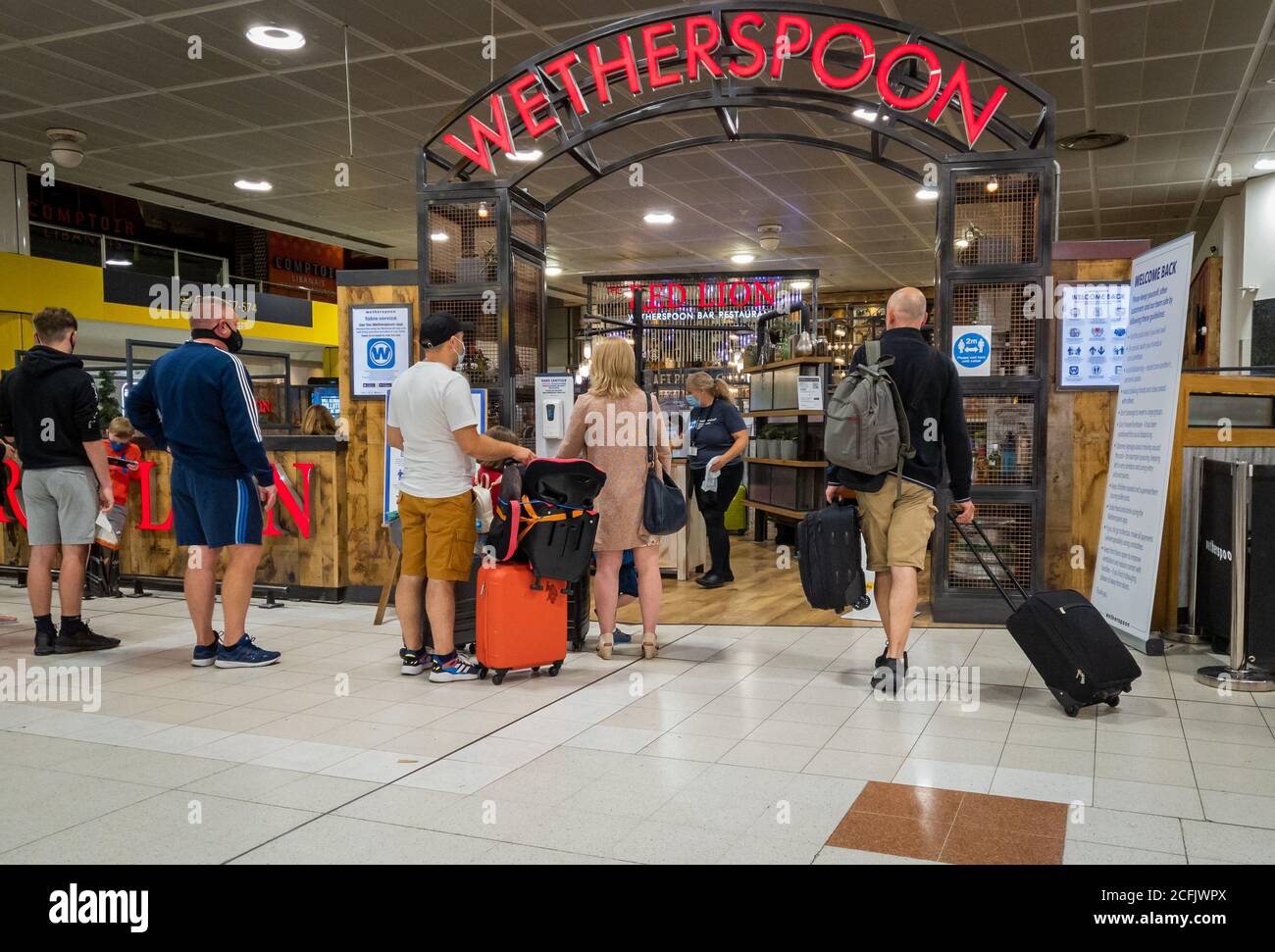 Eine Filiale der Restaurantkette Weatherspoon im Flughafen Gatwick North Terminal mit Flugreisenden, die Schlange stehen, um hereinzukommen. Stockfoto