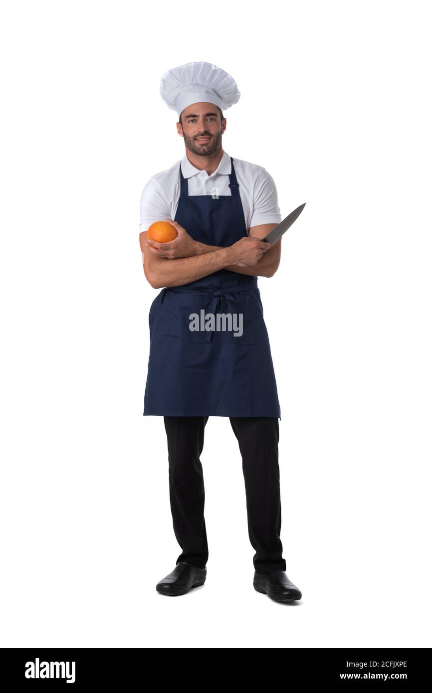 Männlicher Koch in Schürze und Hut hält Orange und Messer isoliert auf weißem Hintergrund, in voller Länge Porträt Stockfoto