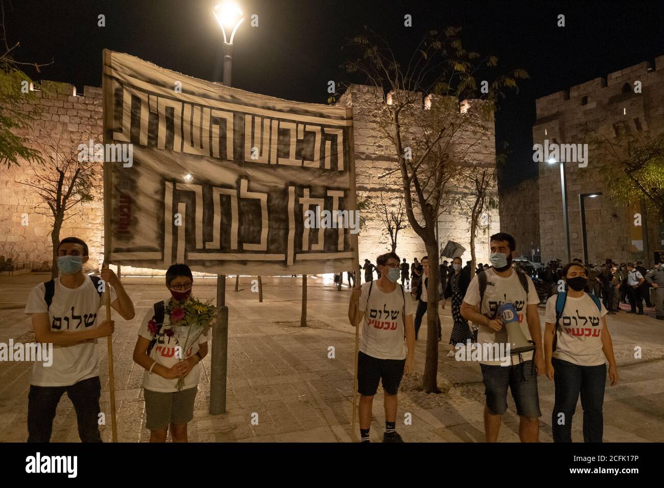 JERUSALEM, ISRAEL - SEPTEMBER 05: Die israelischen linken Aktivisten und Anhänger des Friedens nun halten ein großes Banner, auf dem die korrupte Besatzung "Es ist Zeit, es zu reparieren" vor den alten Stadtmauern durch die Innenstadt von Jerusalem steht, auf dem Weg zur offiziellen Residenz des Premierministers während einer Massendemonstration, an der teilgenommen wird Mehr als 15000 Personen im Rahmen der laufenden Demonstrationen gegen Premierminister Benjamin Netanjahu in der 11. Woche in Folge wegen seiner Anklage wegen Korruptionsvorwürfen und des Umgangs mit der Coronavirus-Pandemie am 05. September 2020 in Jerusalem, Israel. Stockfoto