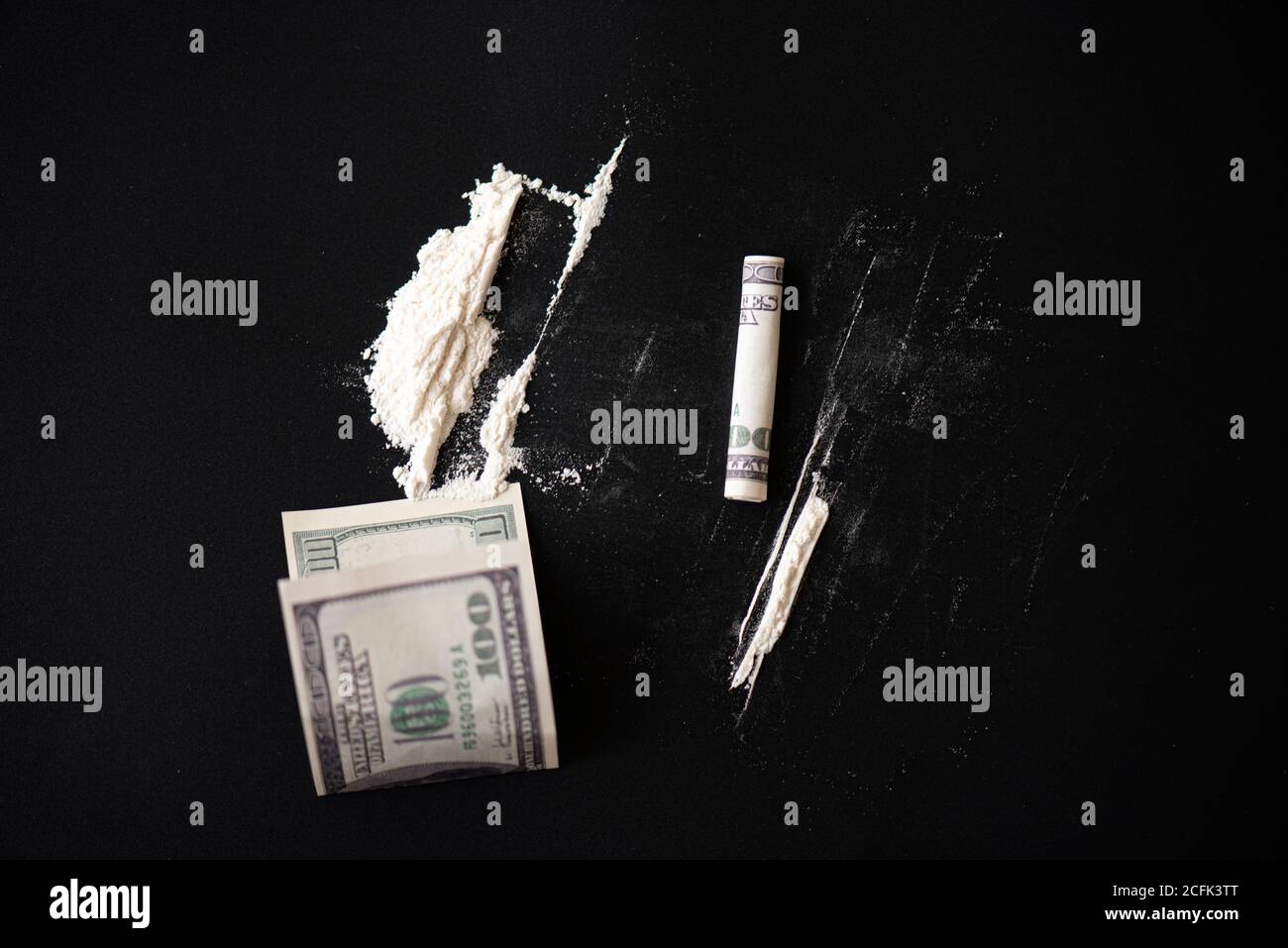 Weißes Pulver als Droge mit Geld auf schwarzer Oberfläche, Konzeptbild Stockfoto