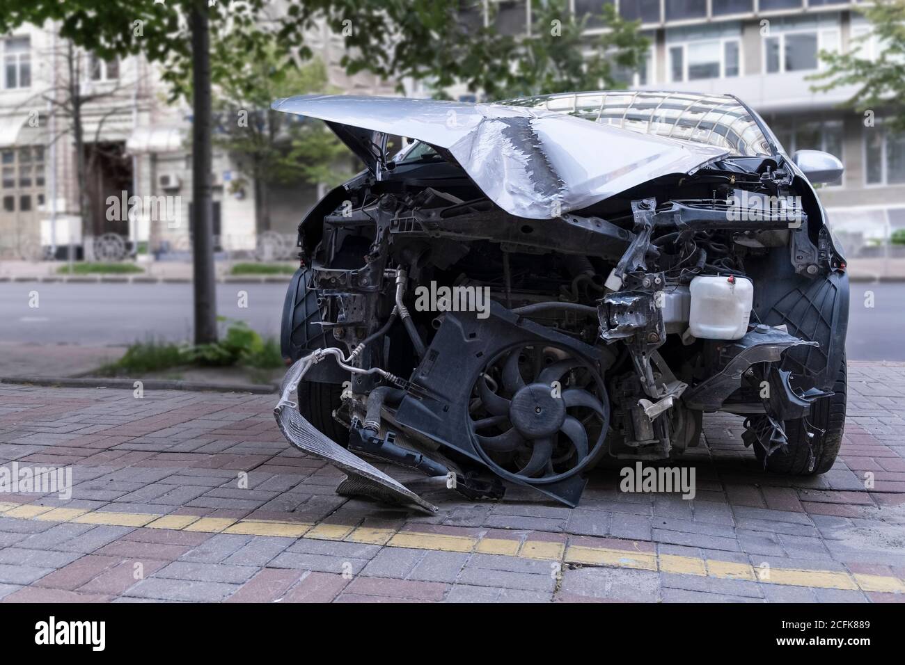 Car Crush. Nahaufnahme eines zerstörten Autos. Auto nach Frontalaufprall. Verbogene Haube und gebrochene Teile Stockfoto