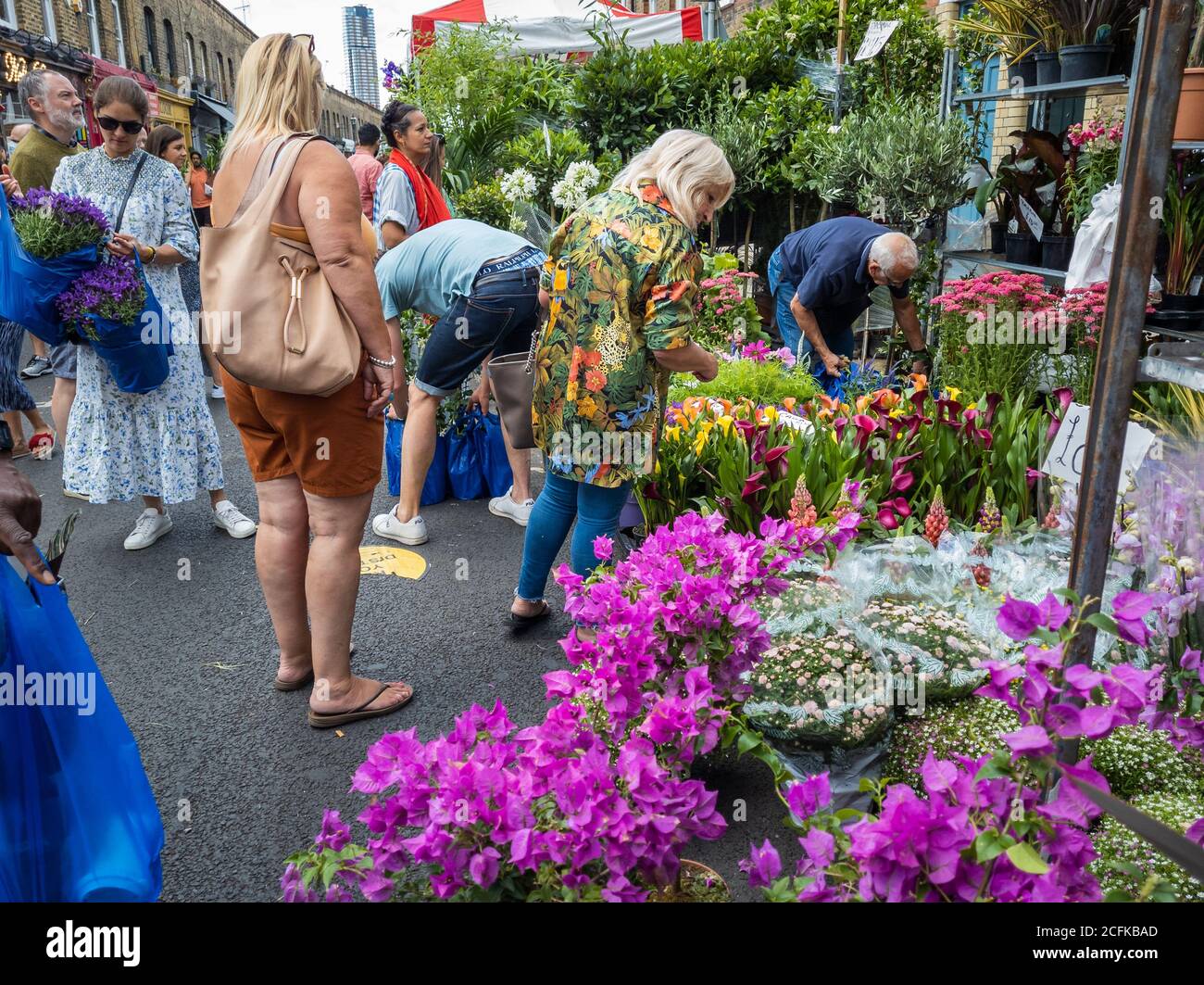 Besucher und Touristen kaufen Blumen von den Händlern in Columbia Road Blumenmarkt. Stockfoto