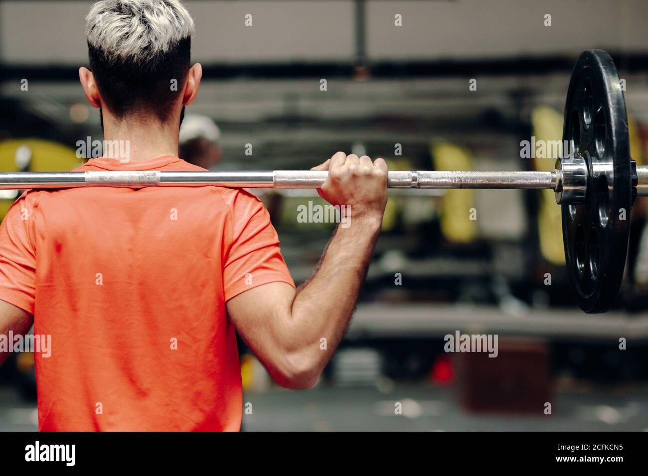 Von hinten Kornansicht des männlichen Athleten Heben schwere Langhantel Bei intensivem Training im modernen Sportclub Stockfoto