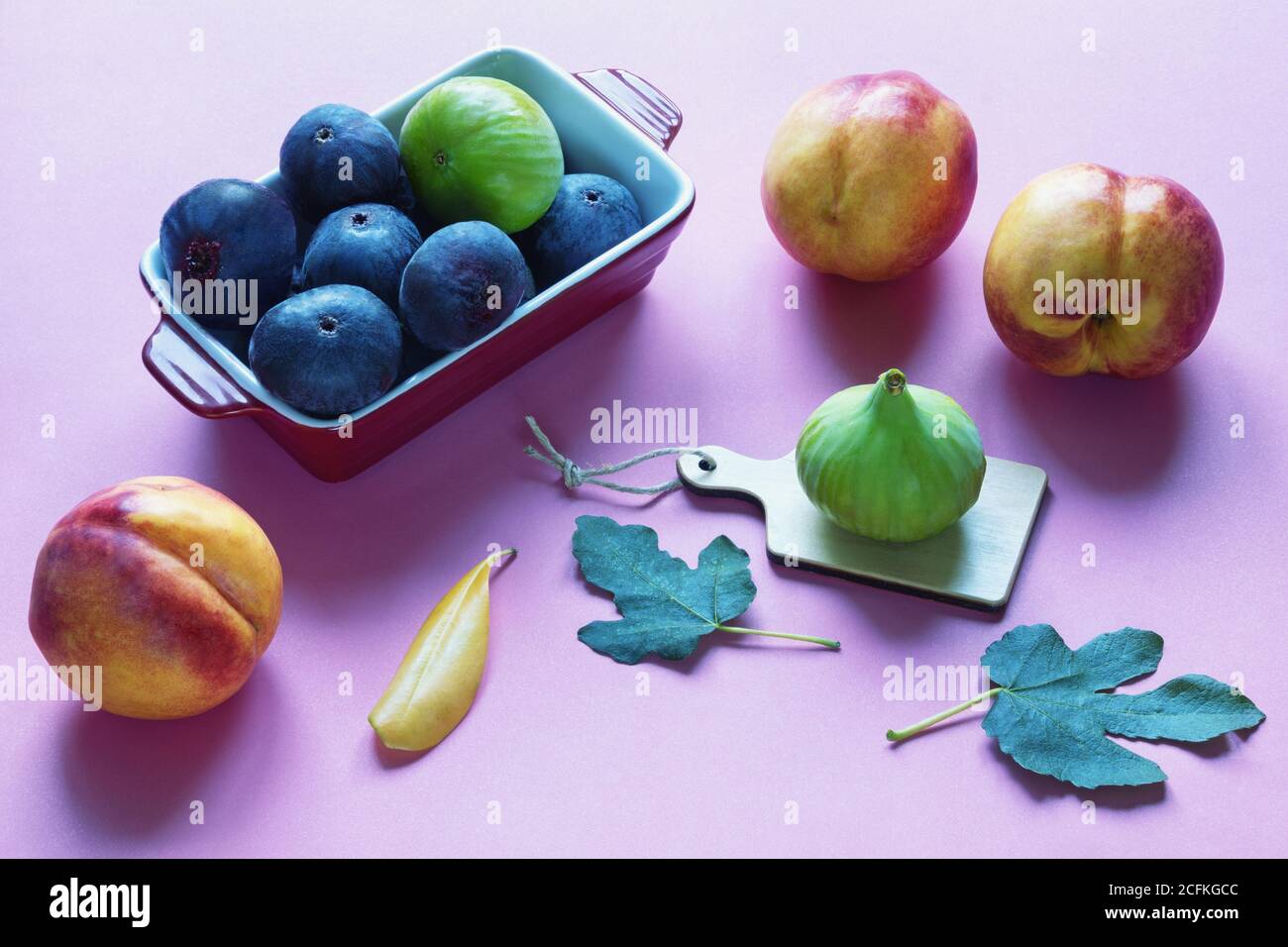 Helle Herbstfrüchte - grüne und violette Feigen und rosa Pfirsiche. Freier Speicherplatz für Text Stockfoto