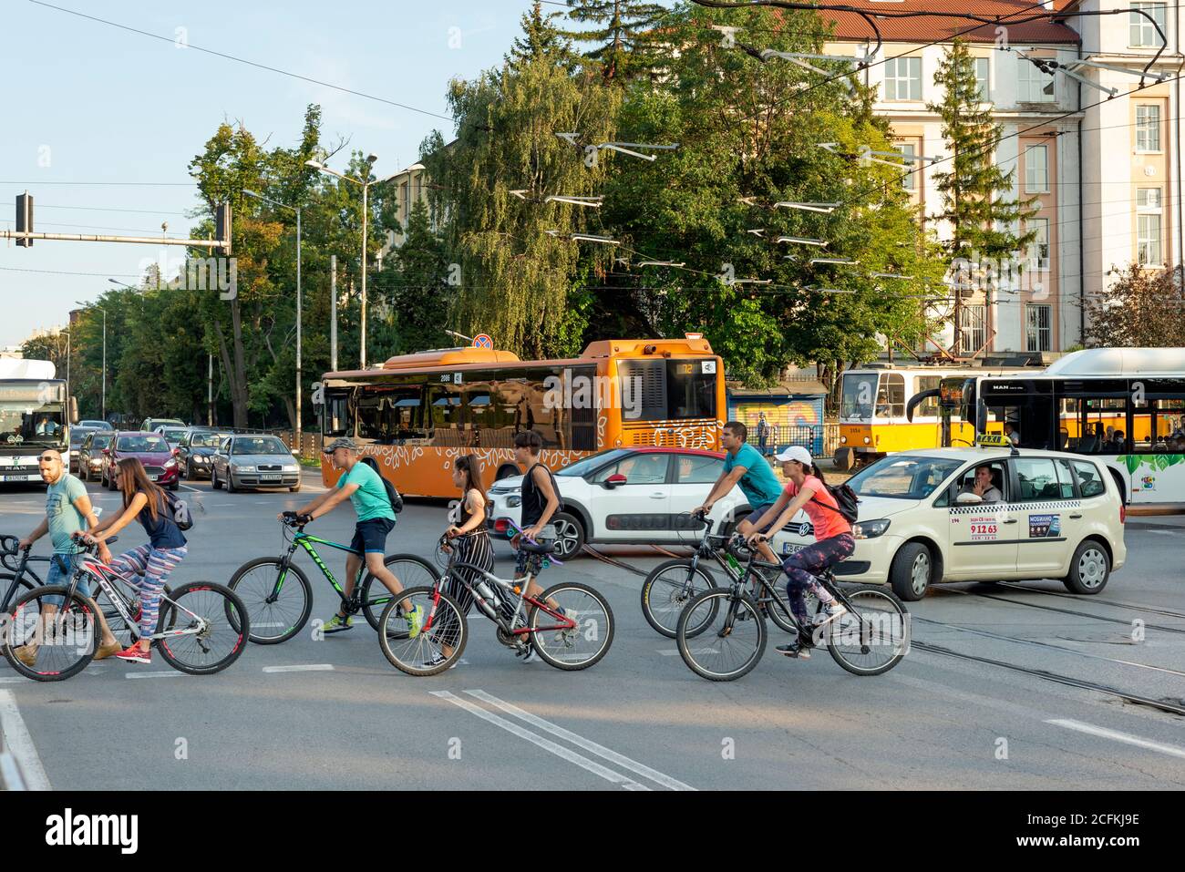 Geschäftige städtische Straßenszene während der Hauptverkehrszeit mit Autoverkehr Busse Straßenbahnen Pendler Menschen und Radfahrer in der Innenstadt von Sofia Bulgarien Stockfoto