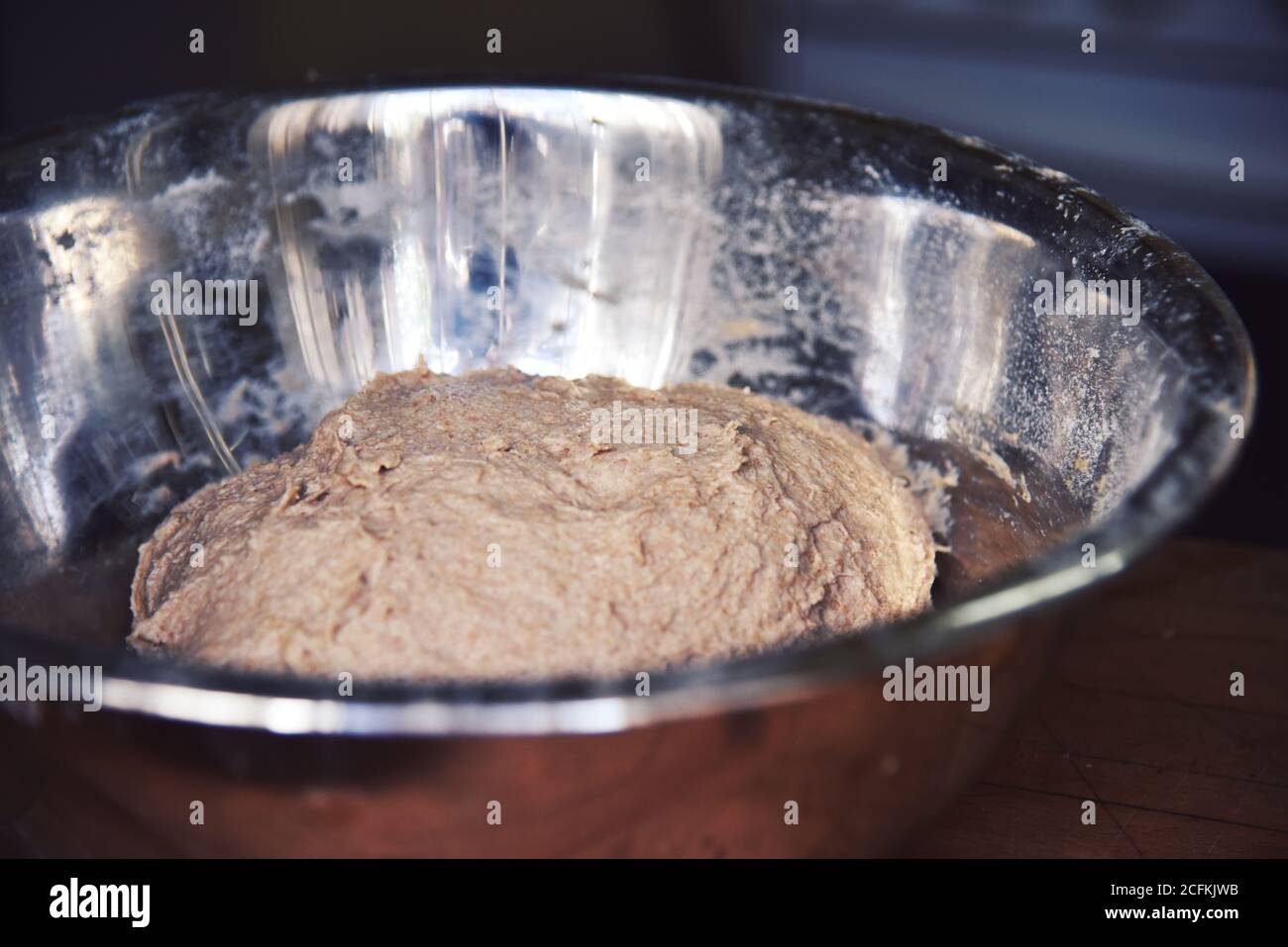 Eine Nahaufnahme einer Edelstahlschale. Handgemachter Brotteig, der in einer Edelstahlschale aufsteigt. Hochwertige Fotos. Stockfoto