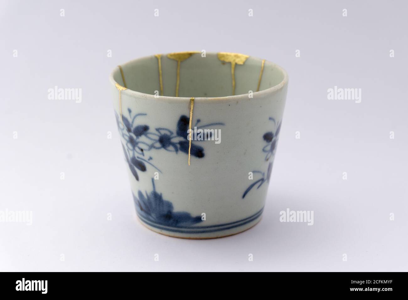Kintsugi weiß und blau Soba Tasse. Gold Risse Restaurierung auf alten japanischen Keramik. Stockfoto