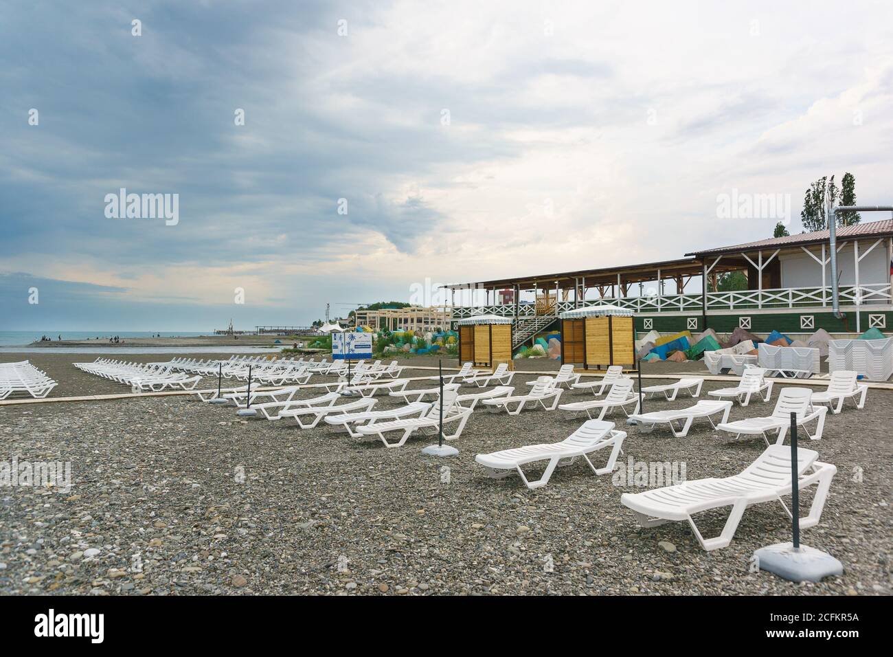 Sotschi, Region Krasnodar, Russland - Juni 06.2017: Einsamer Strand mit Sonnenliegen mit einem bewölkten Tag. Der Beginn der Strandsaison Stockfoto