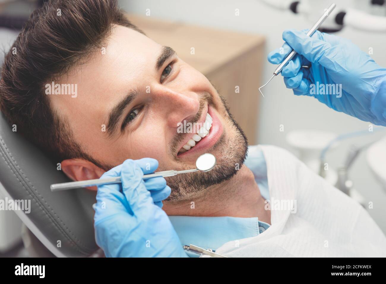 Mann, der Zähne Zahnärzte untersucht. Übersicht von Karies Vorbeugung Stockfoto