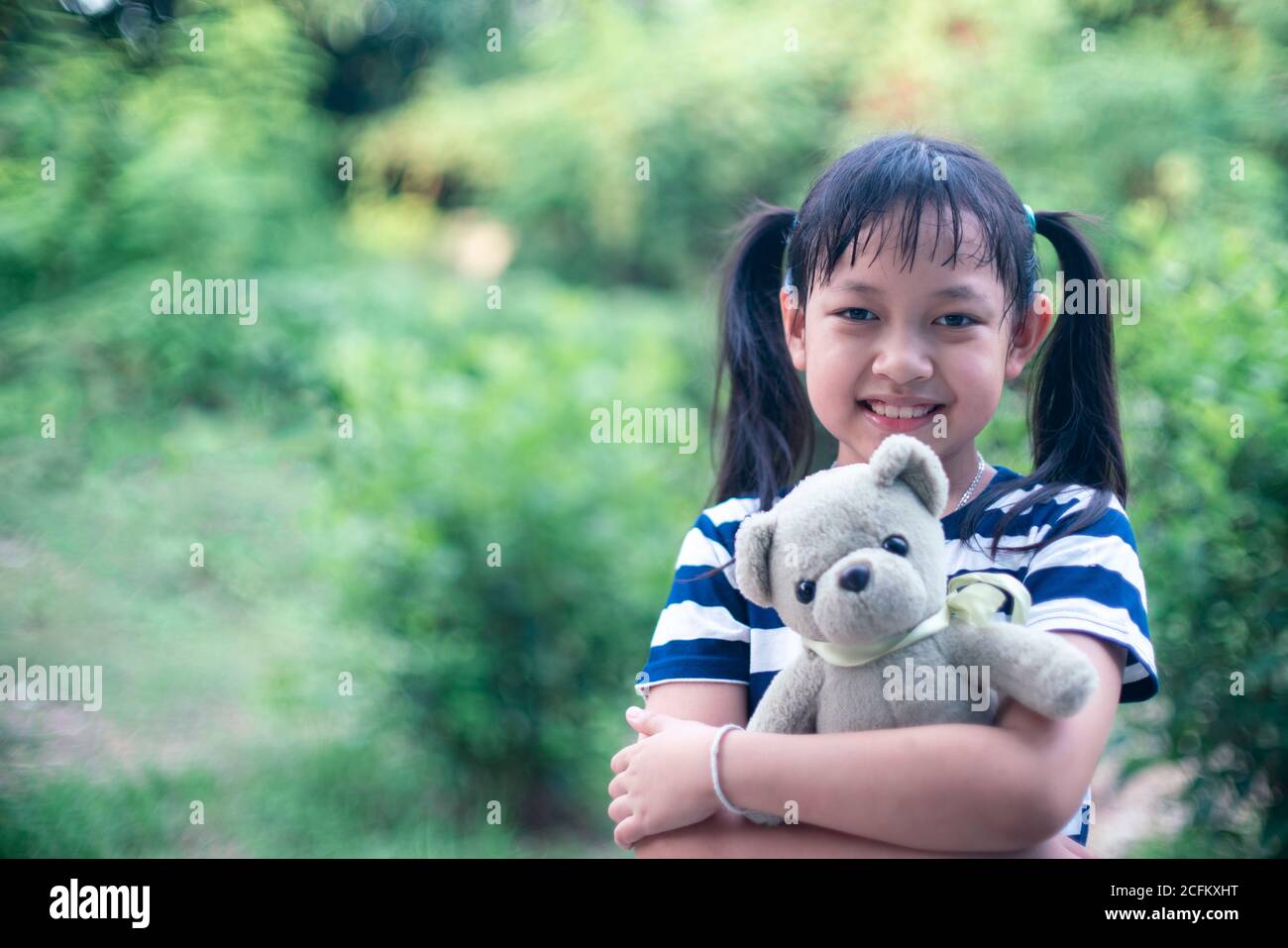 Lächeln kleines Kind Mädchen umarmt Teddybär mit Liebe Stockfoto