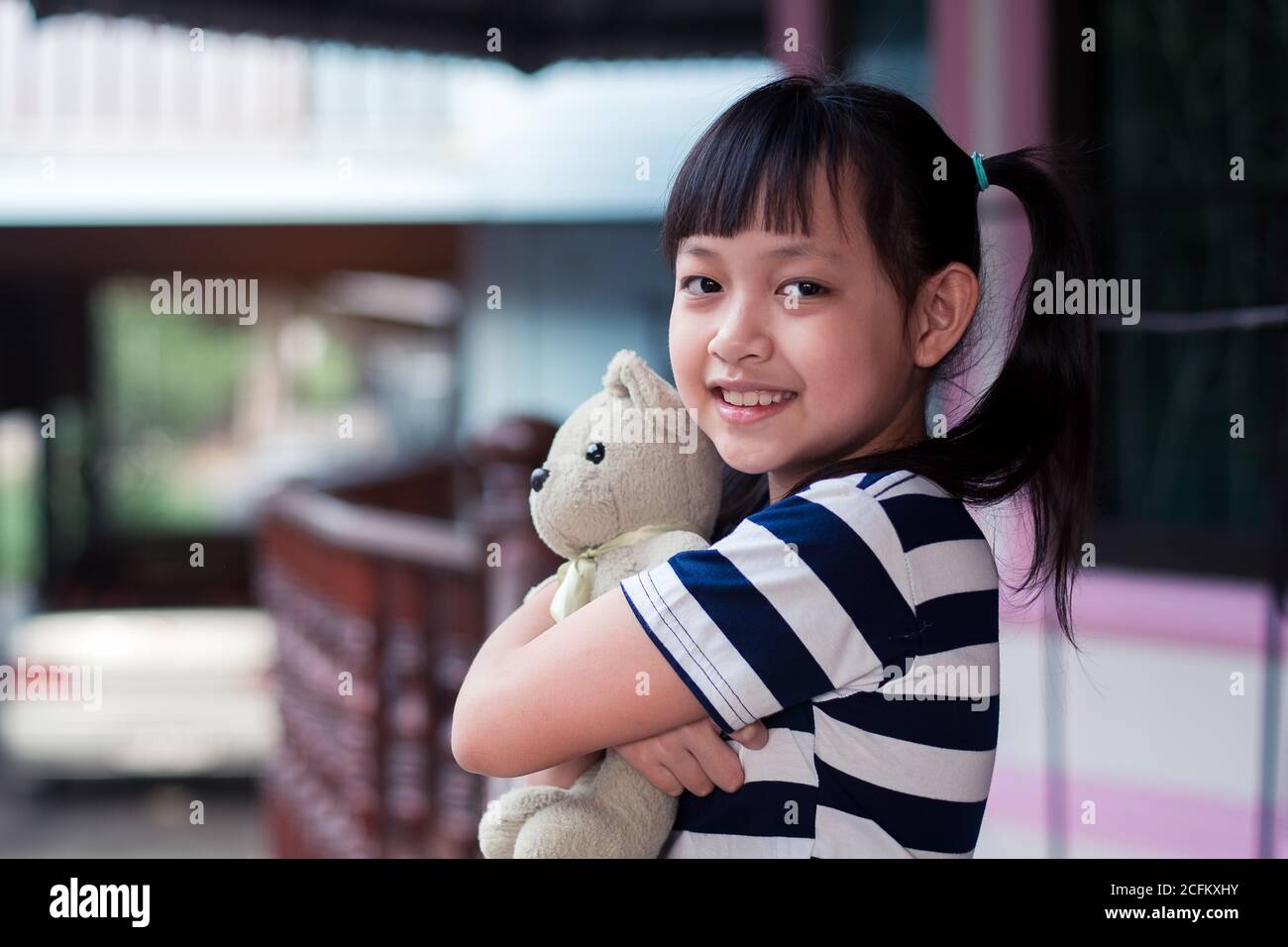 Lächeln kleines Kind Mädchen hält Teddybär mit Liebe Stockfoto
