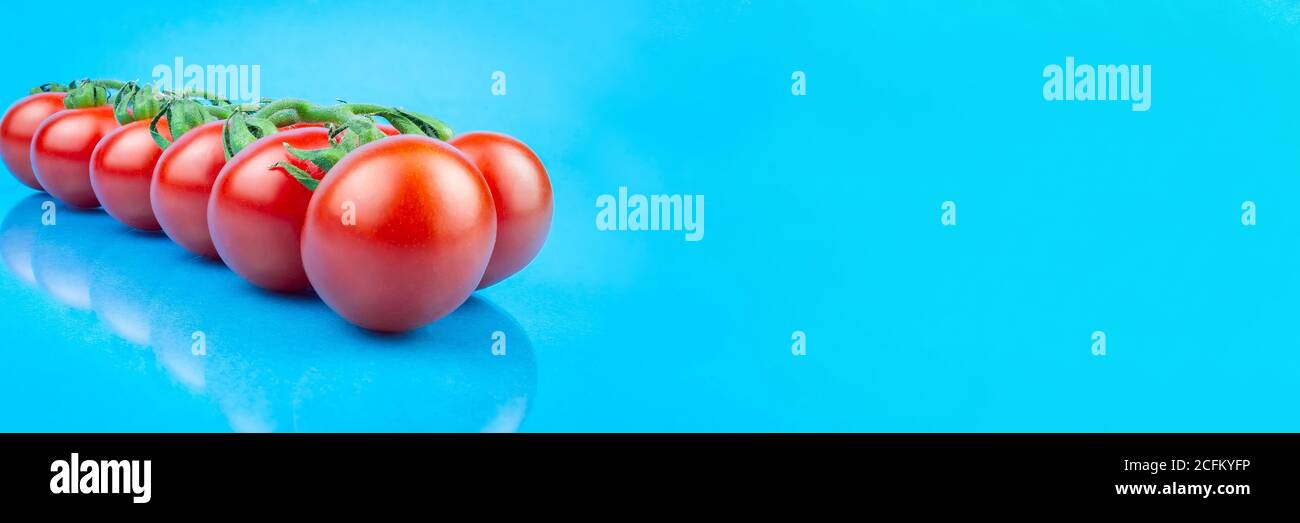 Katzenkirschtomaten auf blauem Hintergrund, Draufsicht. Foto-Banner, Platz für Text Stockfoto