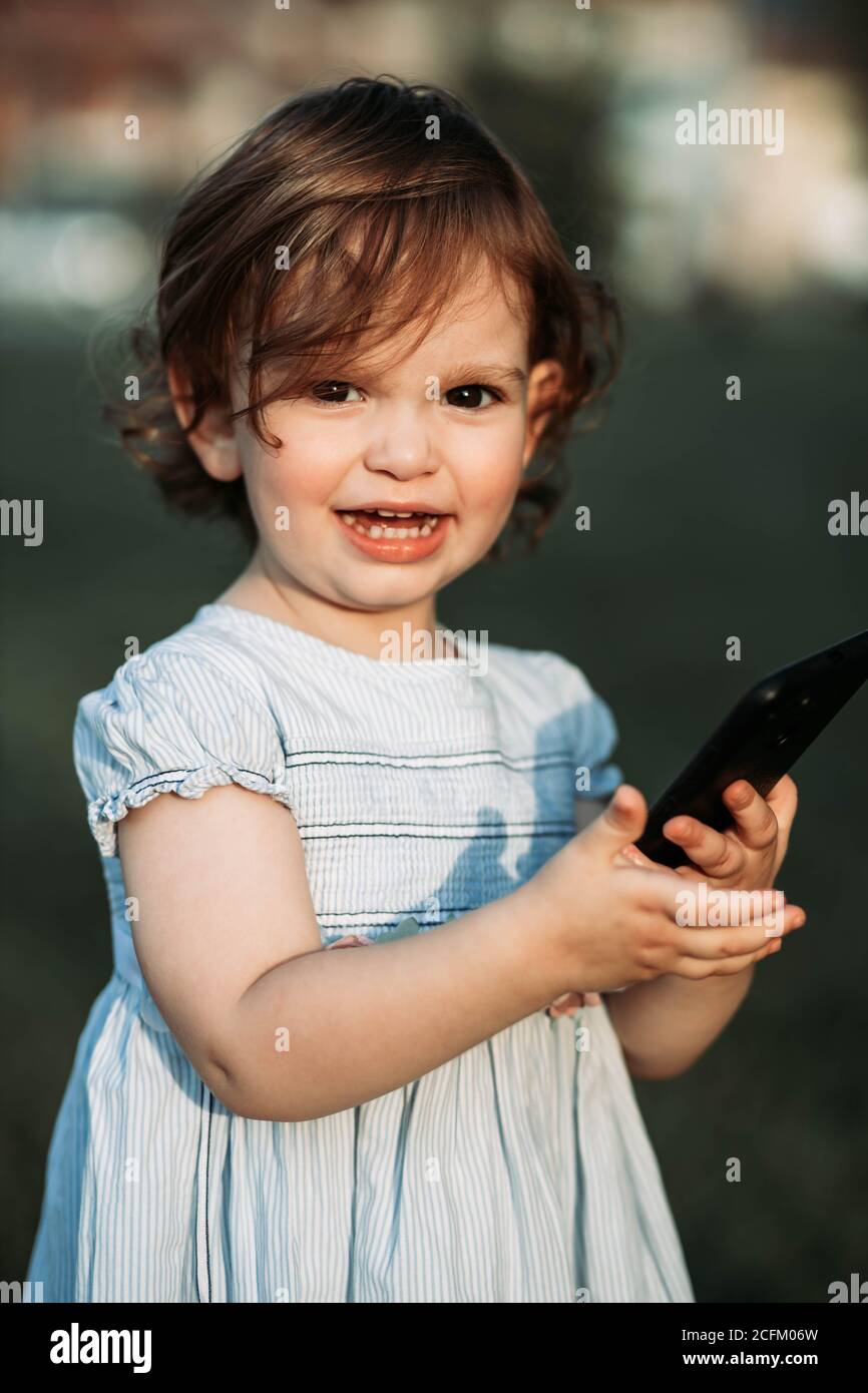 Niedlich, kleine zwei Jahre alte Mädchen hält Telefon und sieht sehr glücklich. Speicherplatz kopieren Stockfoto