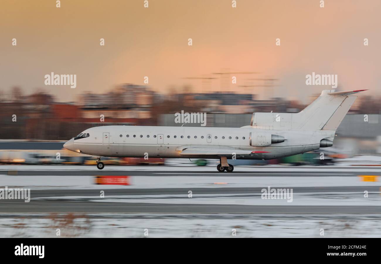 Schmaler Körper regionalen Passagierflugzeug Start bei Sonnenuntergang, Seitenansicht in Bewegung, dramatischen Himmel auf Hintergrund.Aviation Konzept Stockfoto