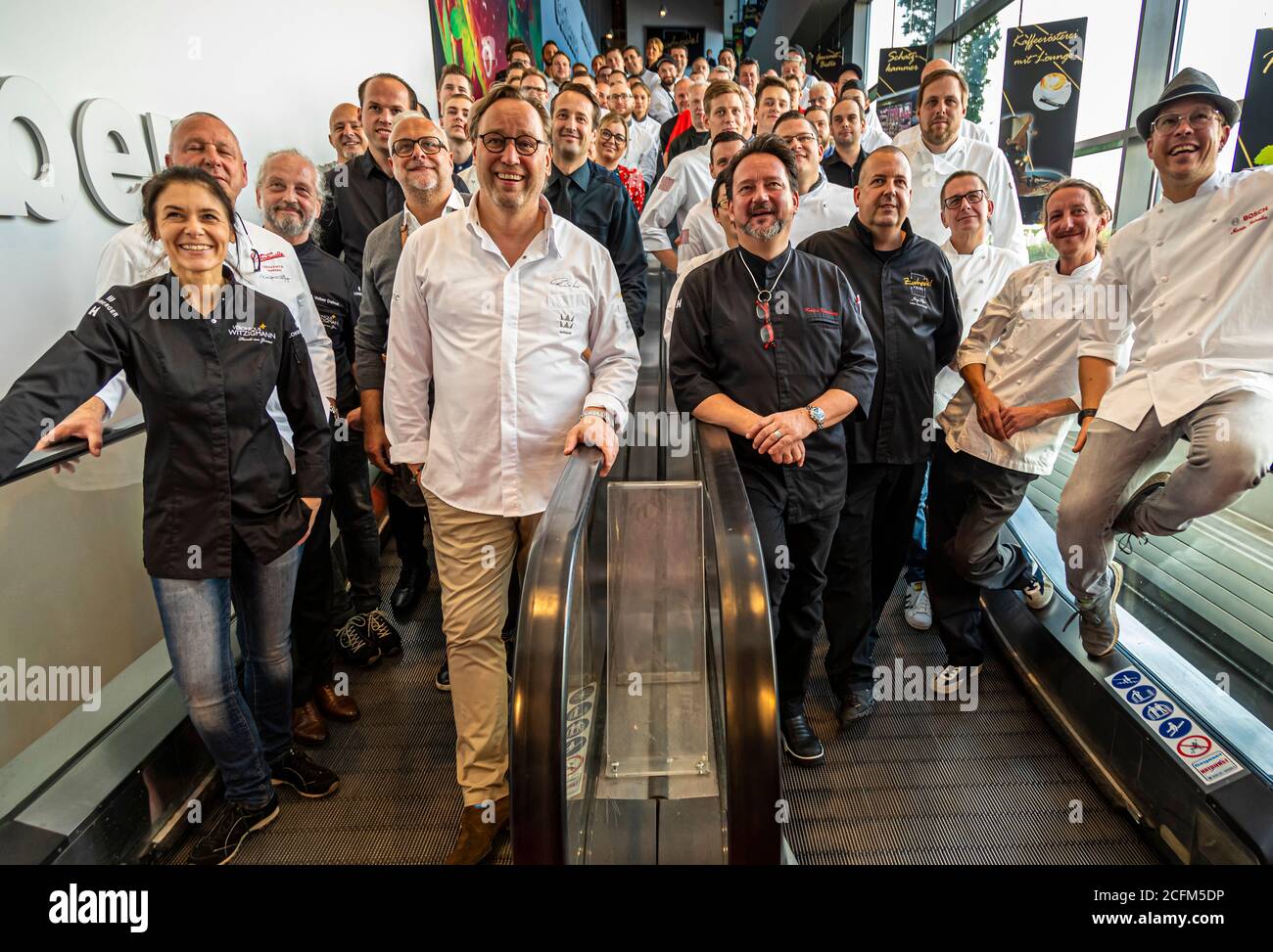 Gruppenfoto von Michelin-Sterneköchen auf einer Rolltreppe auf der EDEKA Zurheide Food Messe in Düsseldorf, Deutschland Stockfoto
