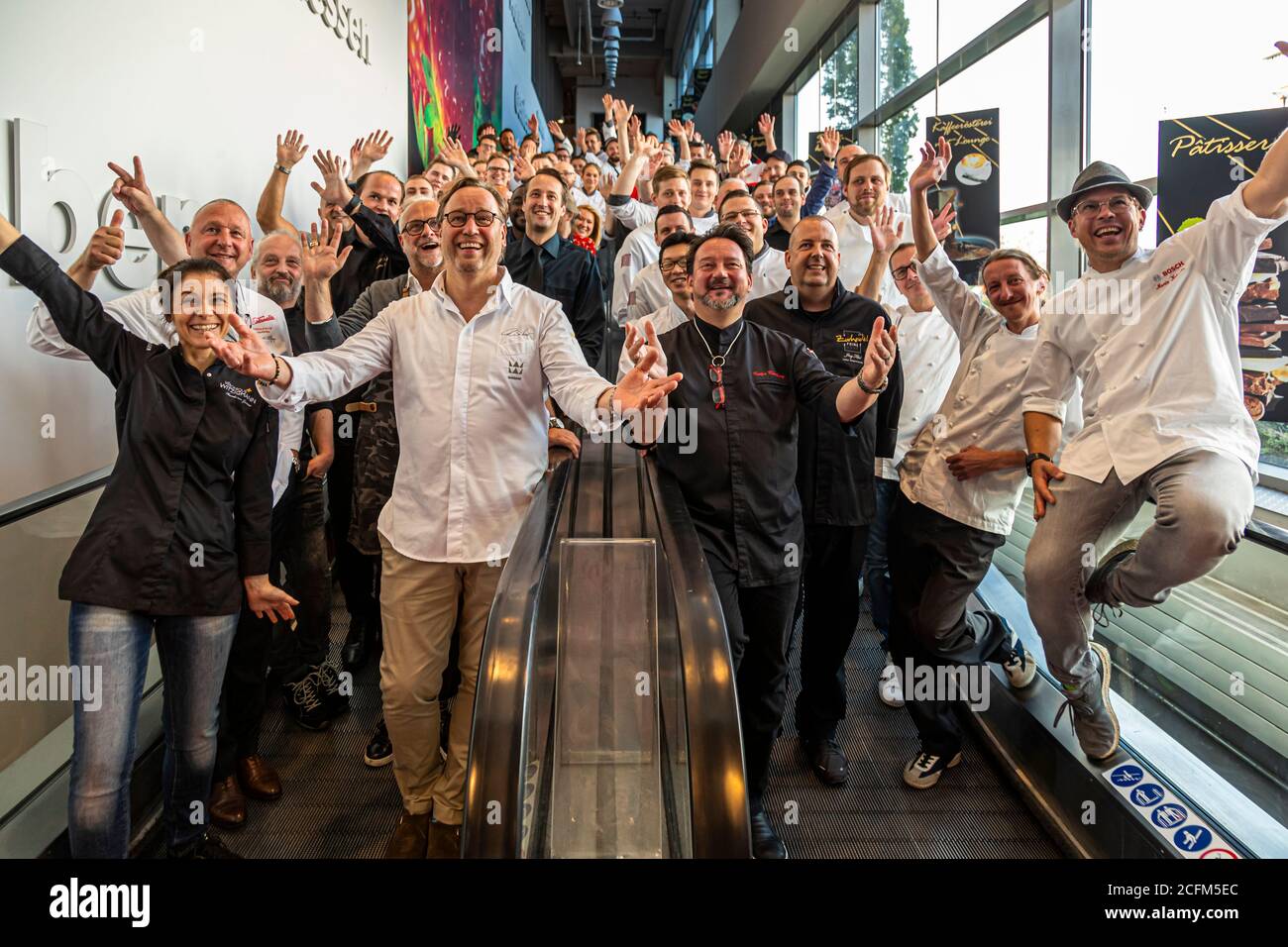 Gruppenfoto von Michelin-Sterneköchen auf einer Rolltreppe auf der EDEKA Zurheide Food Messe in Düsseldorf, Deutschland Stockfoto