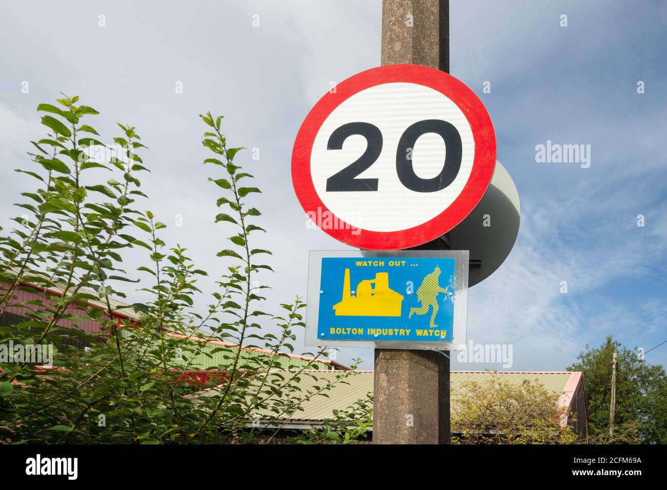 Achten Sie auf Bolton Industrie Uhr, blau und gelb Schild an Beton Lampe Post Straßenlaterne, 20 mph Zeichen angebracht. Farnworth, Bolton, Großbritannien. Stockfoto