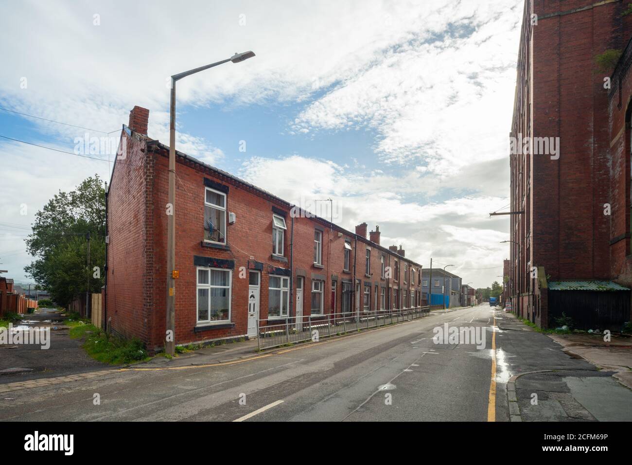 Cawdor Street, Farnworth. Terrassenhäuser aus roten Backsteinen. Die Textilfabrik Bolton Nummer 2 befindet sich auf der rechten Seite. Cotton Mill wurde Anfang 1900er erbaut, möglicherweise 1905. UK. Stockfoto