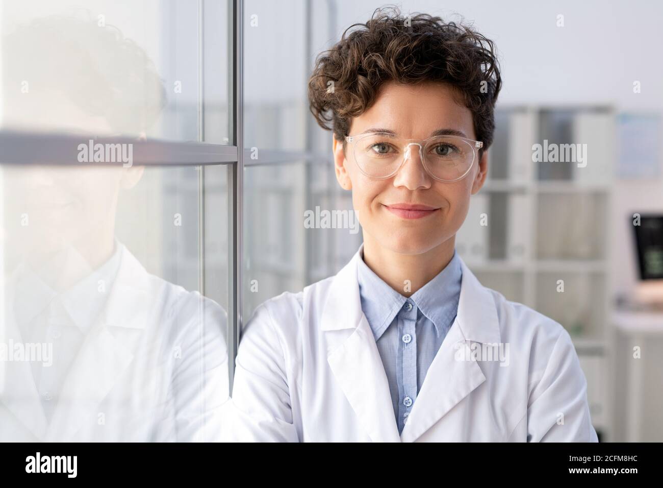 Junge erfolgreiche Arbeiterin der wissenschaftlichen Labor in Whitecoat und Brillen Stockfoto