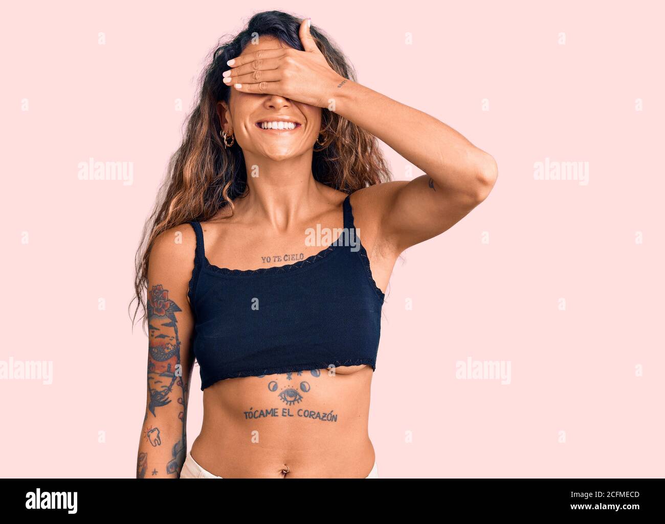 Junge hispanische Frau mit Tattoo tragen Casual Kleidung lächelnd und  lachend mit Hand auf Gesicht deckende Augen für Überraschung. Blind Konzept  Stockfotografie - Alamy