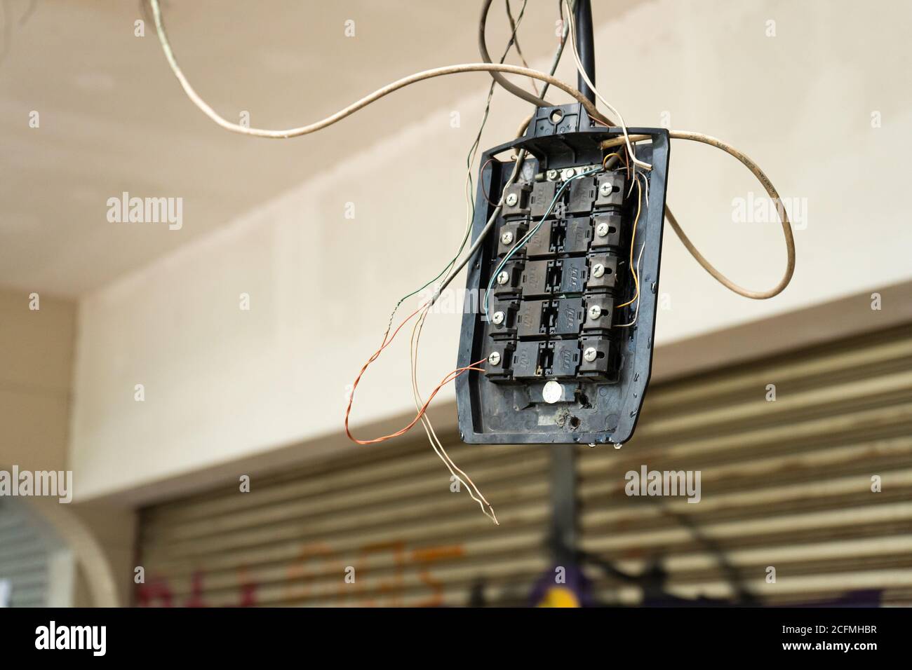 Alte kaputte Stromverteiler hängen an Drähten. Stockfoto