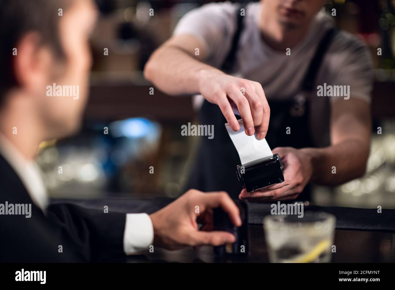 Der Barkeeper akzeptiert die Zahlung per Kreditkarte an der Bar. Stockfoto