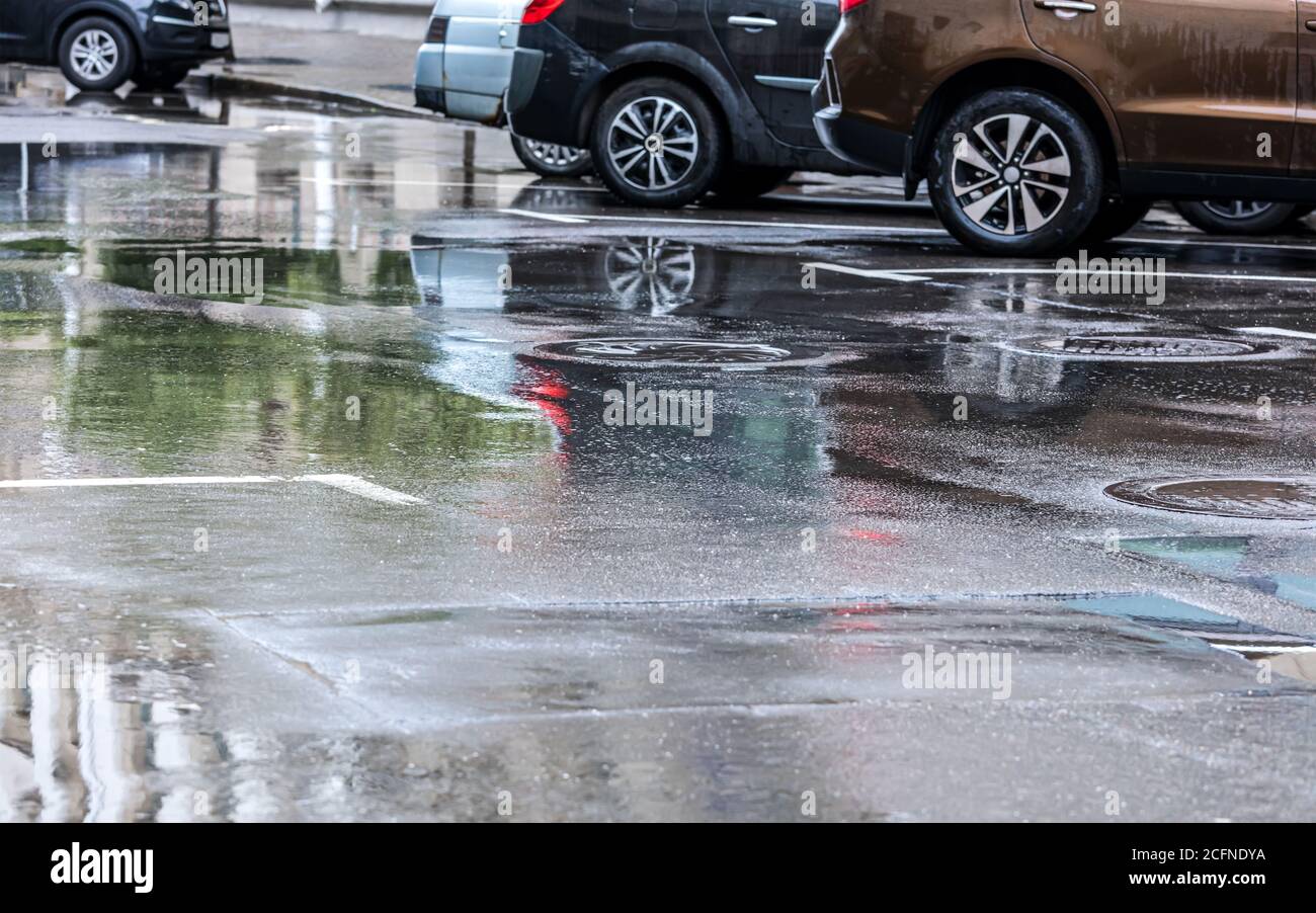 Autos in der Stadt Straße nach sintflutartigen Sommerregen geparkt Stockfoto