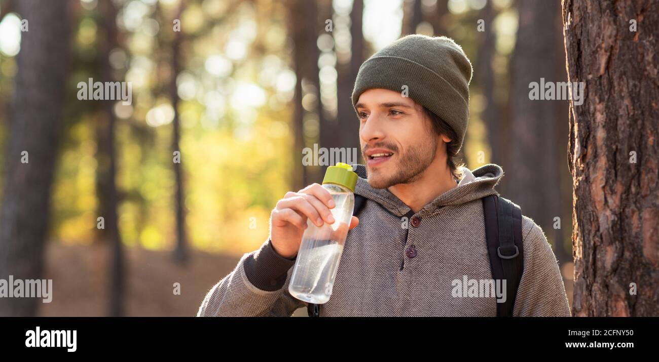 Nahaufnahme eines jungen Mannes, der Wasser im Wald trinkt Stockfoto