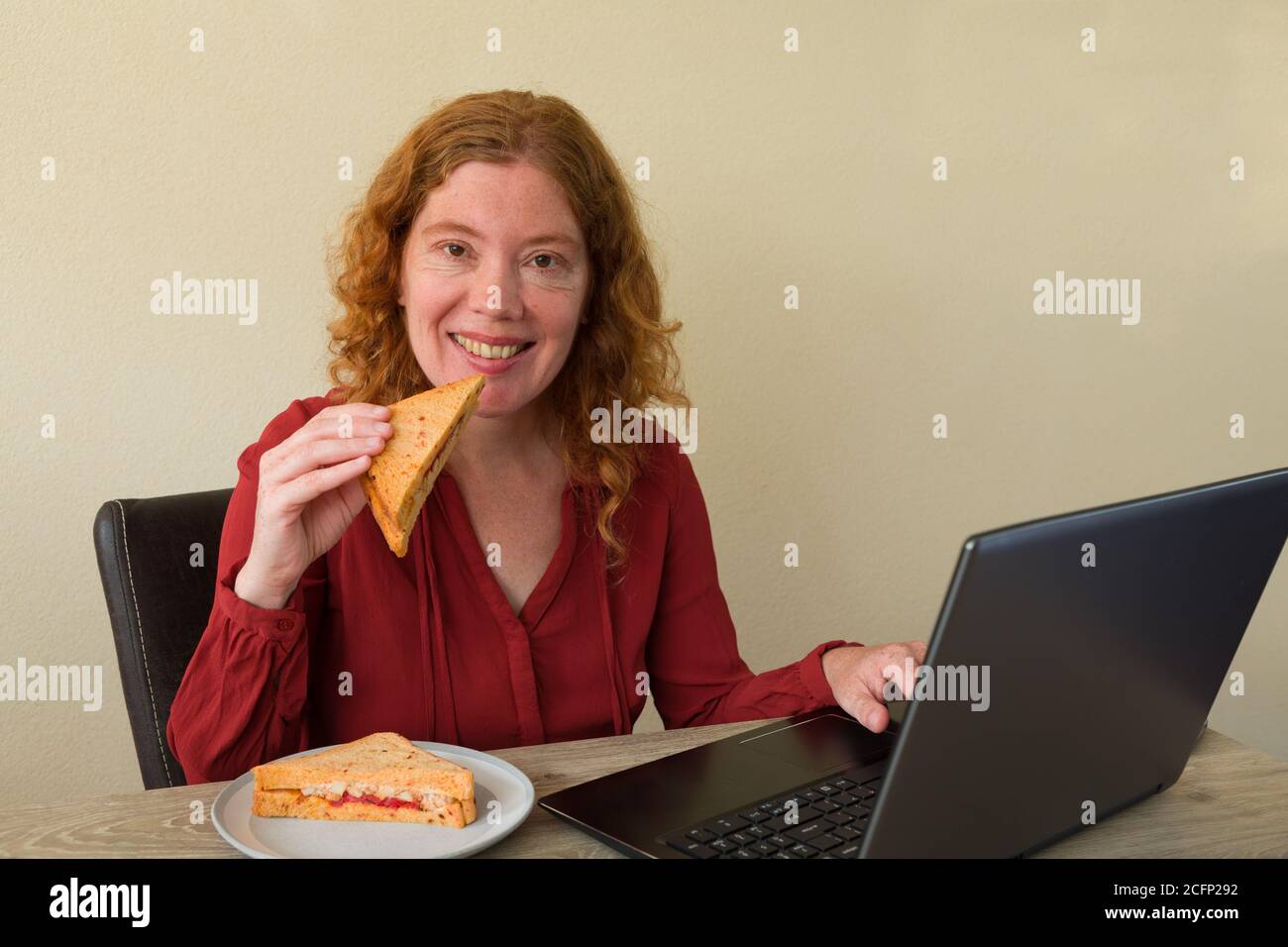 Causasian Frau genießen Frühstück oder Mittagessen während der Arbeit oder lernen Zu Hause Stockfoto