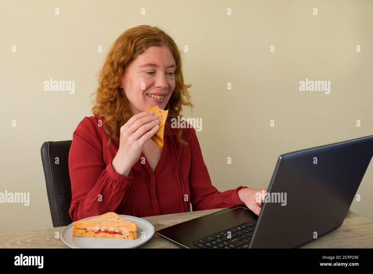 Causasian Frau genießen Frühstück oder Mittagessen während der Arbeit oder lernen Zu Hause Stockfoto