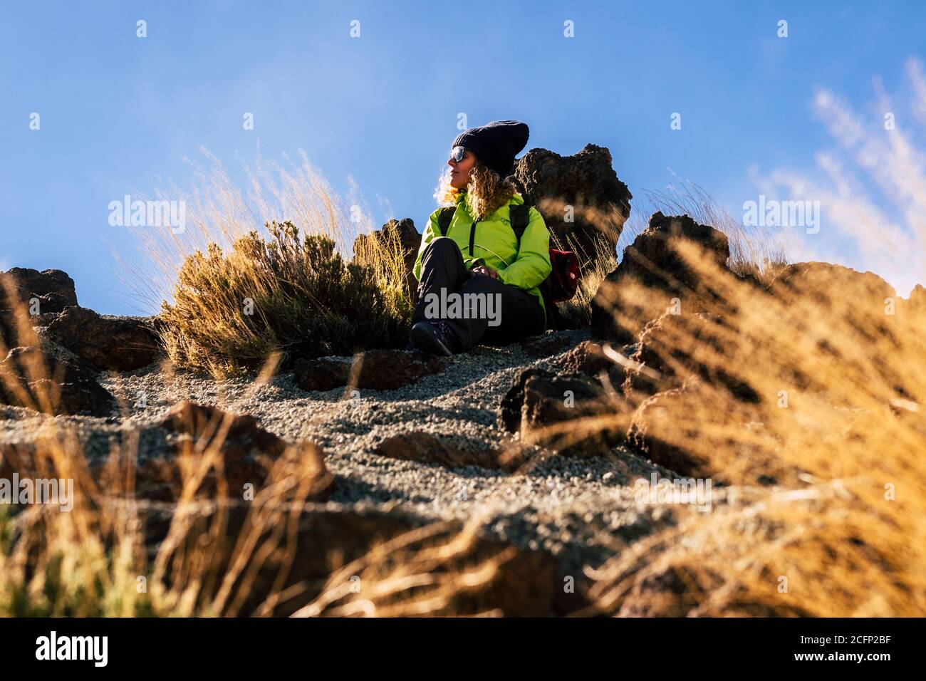 Frau entspannt sitzen auf dem Boden nach einem Trekking Ausflug - Konzept der Reise und Outdoor-Freizeit Sport Wanderung Aktivität mit kaukasischen Menschen enj Stockfoto