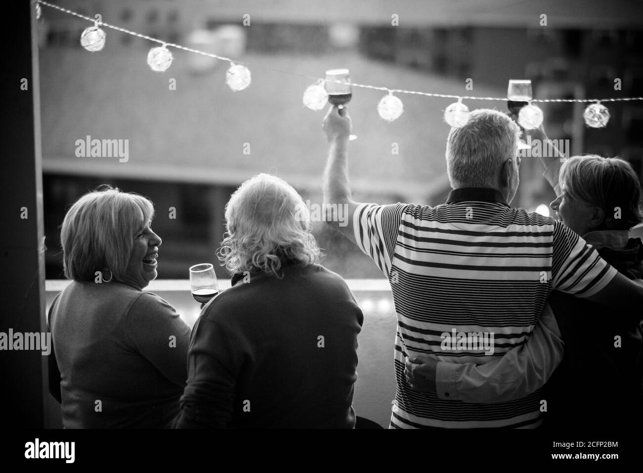 Gruppe von fröhlichen und glücklichen älteren Freunden Menschen klirren und Genießen Sie zusammen das Abendessen im Freien auf der Terrasse zu Hause mit Blick auf die Stadt - Menschen zusammen Stockfoto