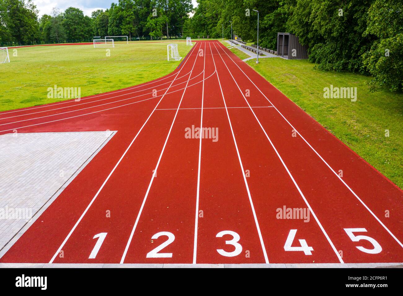 Perspektivische Ansicht eines Freiluftstadions mit rot nummerierten Laufstrecken, Infrastruktur für sportliche Aktivitäten Stockfoto