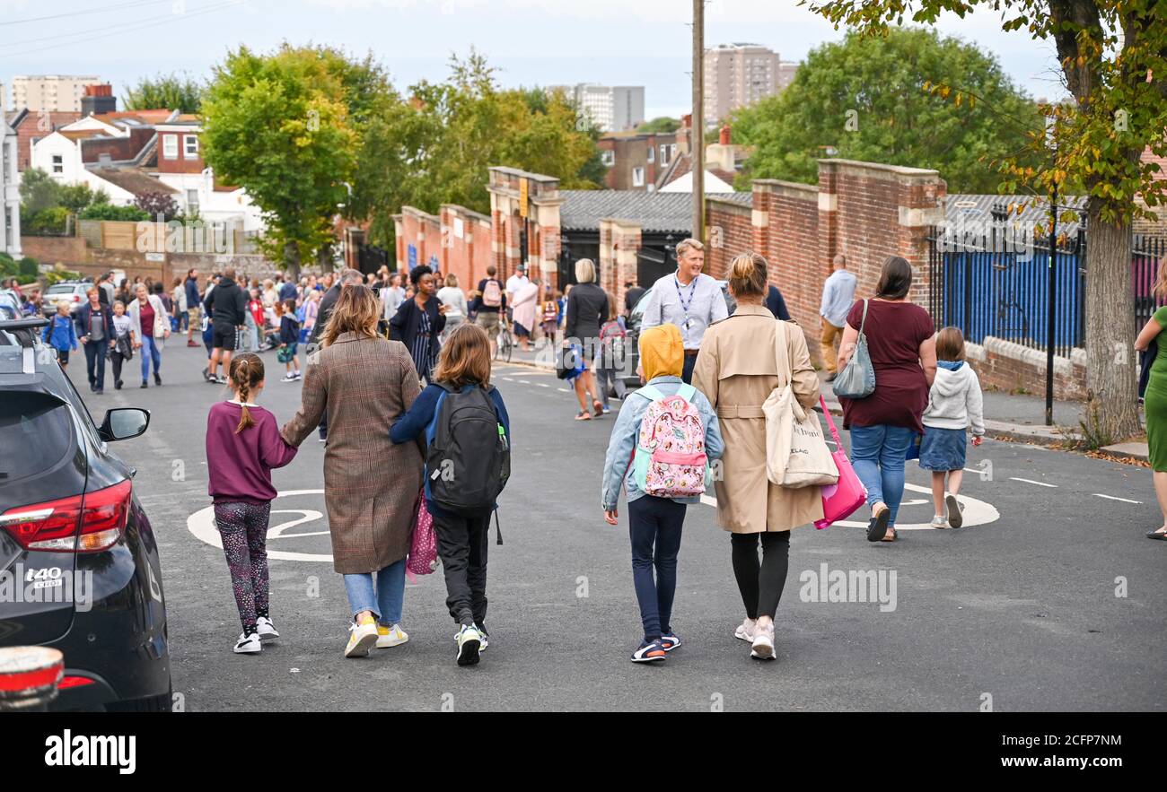 Brighton UK 7. September 2020 - Schüler, Mitarbeiter und Eltern außerhalb der St. Luke's Primary School in Brighton heute Morgen, wo die Straße gesperrt wurde, um bei der sozialen Distanzierung und Verkehrssicherheit bei ihrer Rückkehr zur Bildung zu helfen. Das neue Schulstraßenschema wurde von der stadtverwaltung für den Beginn der Amtszeit im September an vierzehn Schulen eingeführt und wird zweimal täglich für eine Stunde zwischen 8-2-4 Uhr und 22 Uhr durchgesetzt : Credit Simon Dack / Alamy Live News Stockfoto