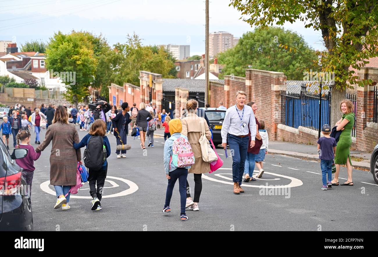 Brighton UK 7. September 2020 - Schüler, Mitarbeiter und Eltern außerhalb der St. Luke's Primary School in Brighton heute Morgen, wo die Straße gesperrt wurde, um bei der sozialen Distanzierung und Verkehrssicherheit bei ihrer Rückkehr zur Bildung zu helfen. Das neue Schulstraßenschema wurde von der stadtverwaltung für den Beginn der Amtszeit im September an vierzehn Schulen eingeführt und wird zweimal täglich für eine Stunde zwischen 8-2-4 Uhr und 22 Uhr durchgesetzt : Credit Simon Dack / Alamy Live News Stockfoto